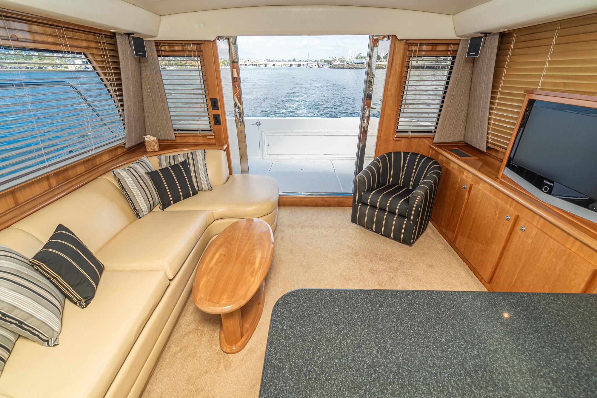 Luxurious 2006 Navigator 5100 yacht interior with elegant seating, wood accents, and ocean view.