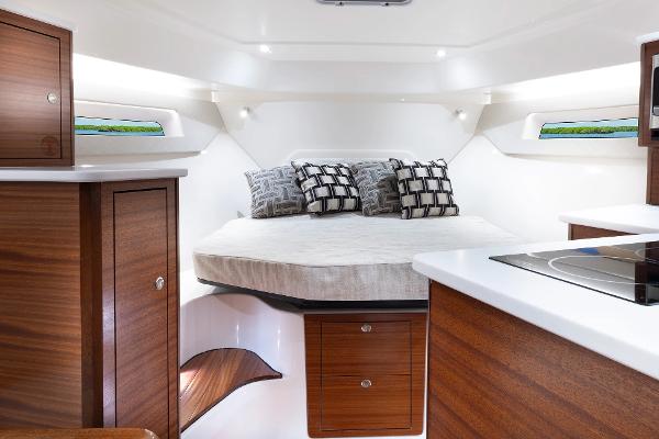 Luxurious cabin interior of 2025 Pursuit OS 405 boat with modern wood finishes.