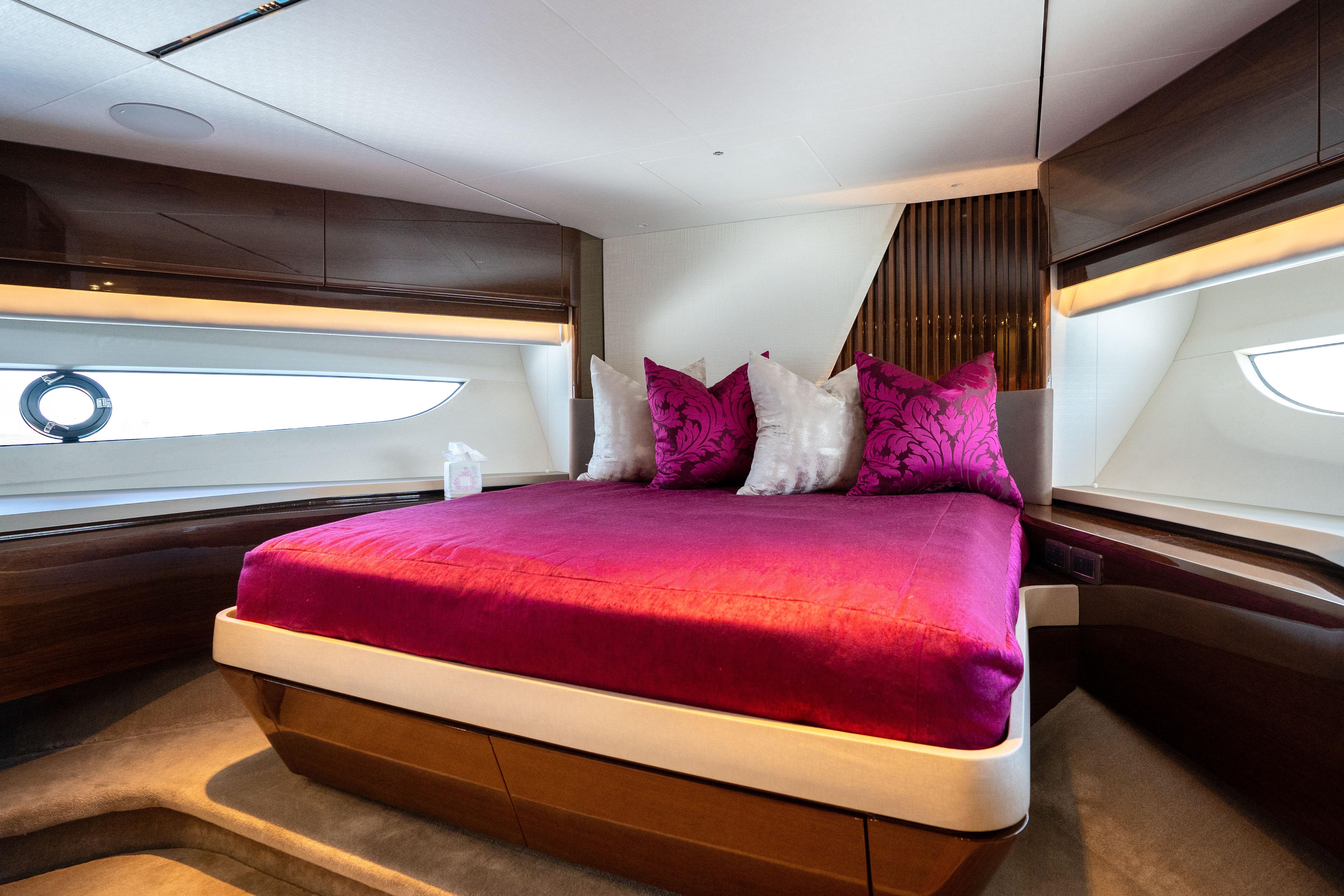 Luxurious bedroom interior of 2020 Princess Y85 yacht with vibrant pink bedding.