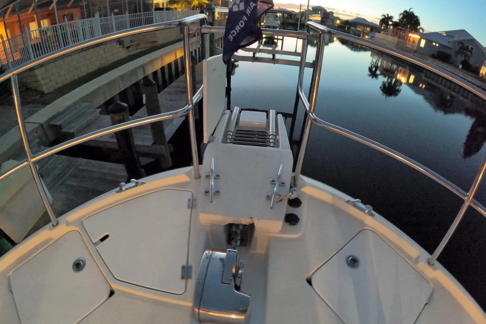 Bow view of 2015 Ranger Tugs R-29 S at sunset, docked by calm water.