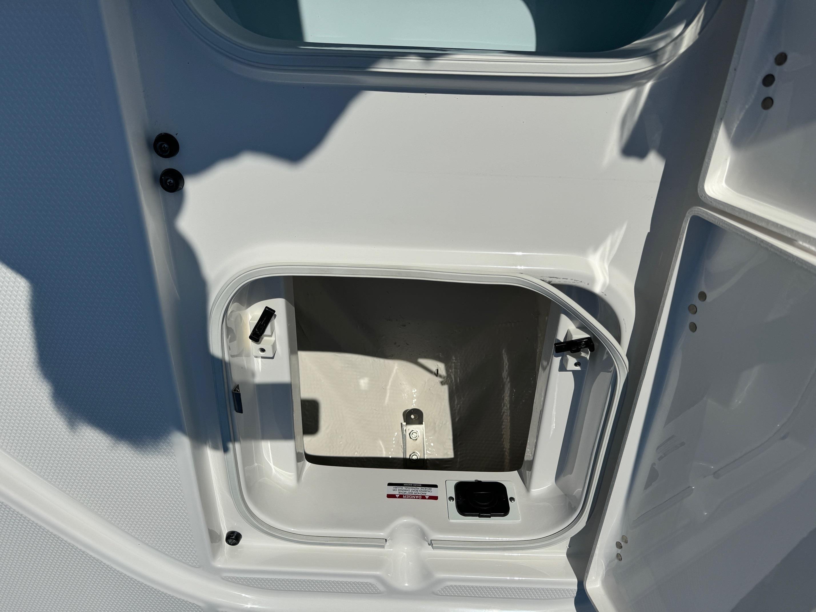 2025 Robalo R246 CAYMAN storage compartment with open hatch, showcasing interior space.
