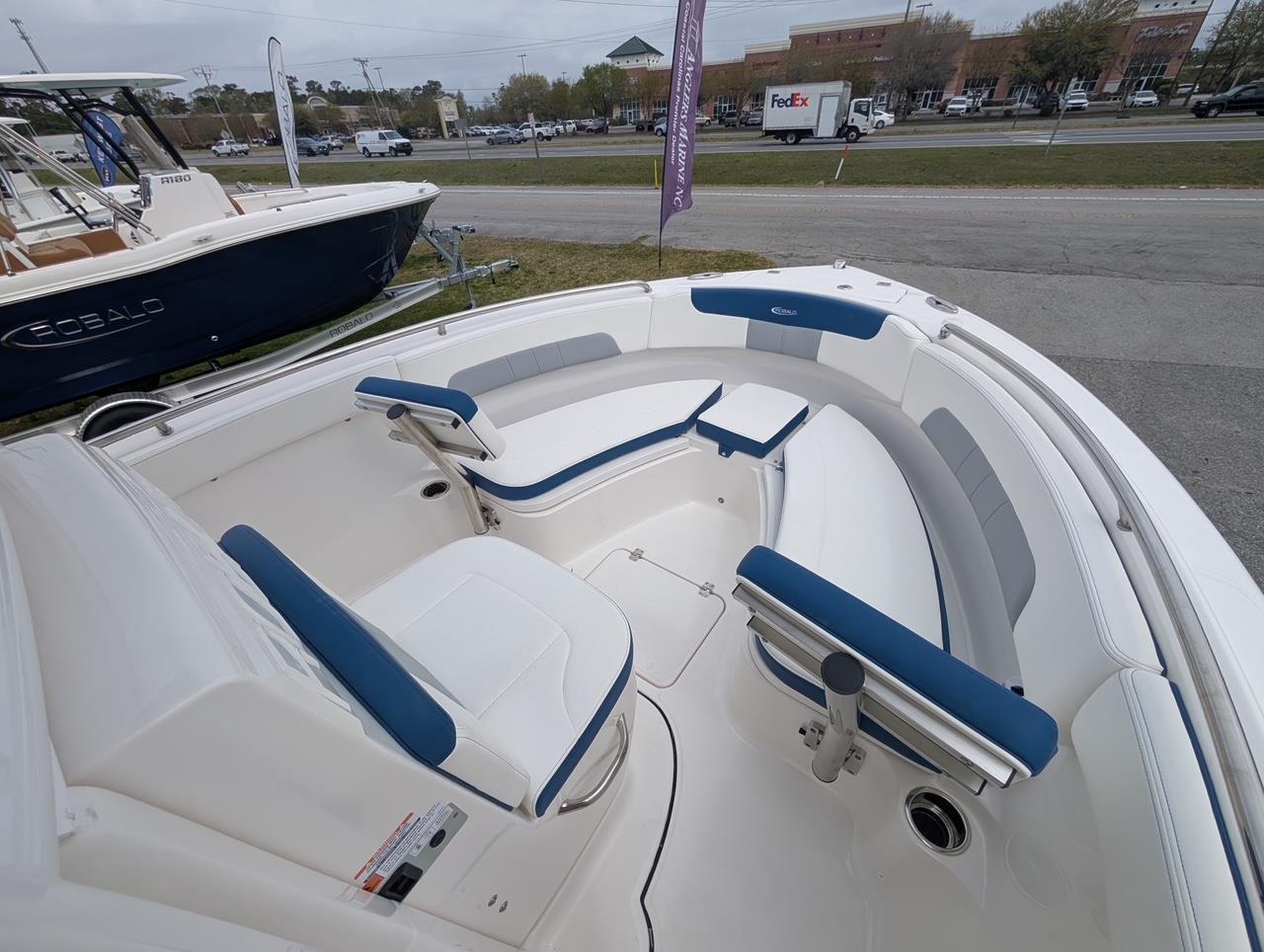 2025 Robalo R222 Explorer boat interior with blue and white seating, parked outdoors.