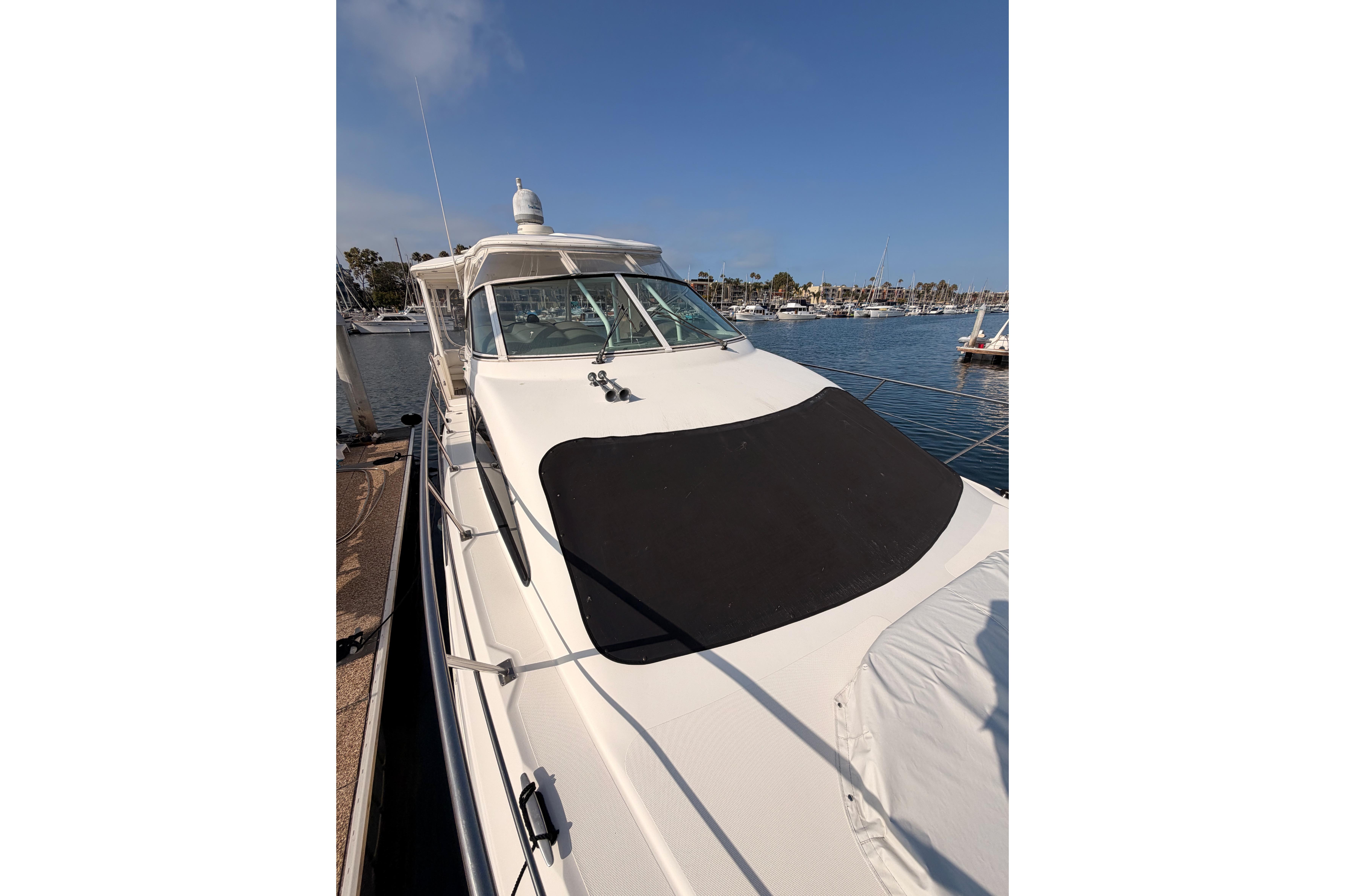 2005 Cruisers Yachts 405 Express Motoryacht docked at marina under clear blue sky.