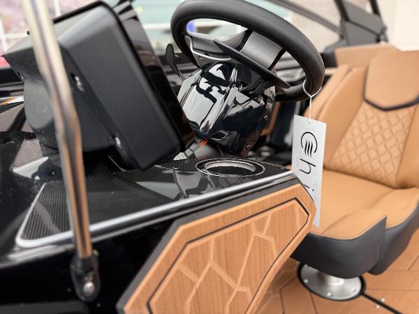 2025 Yamaha Boats 255XD interior with steering wheel and tan seating.