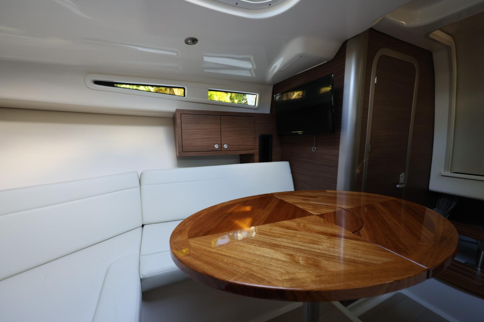 Luxurious interior of 2025 Boston Whaler 325 Conquest with elegant wood table and seating.