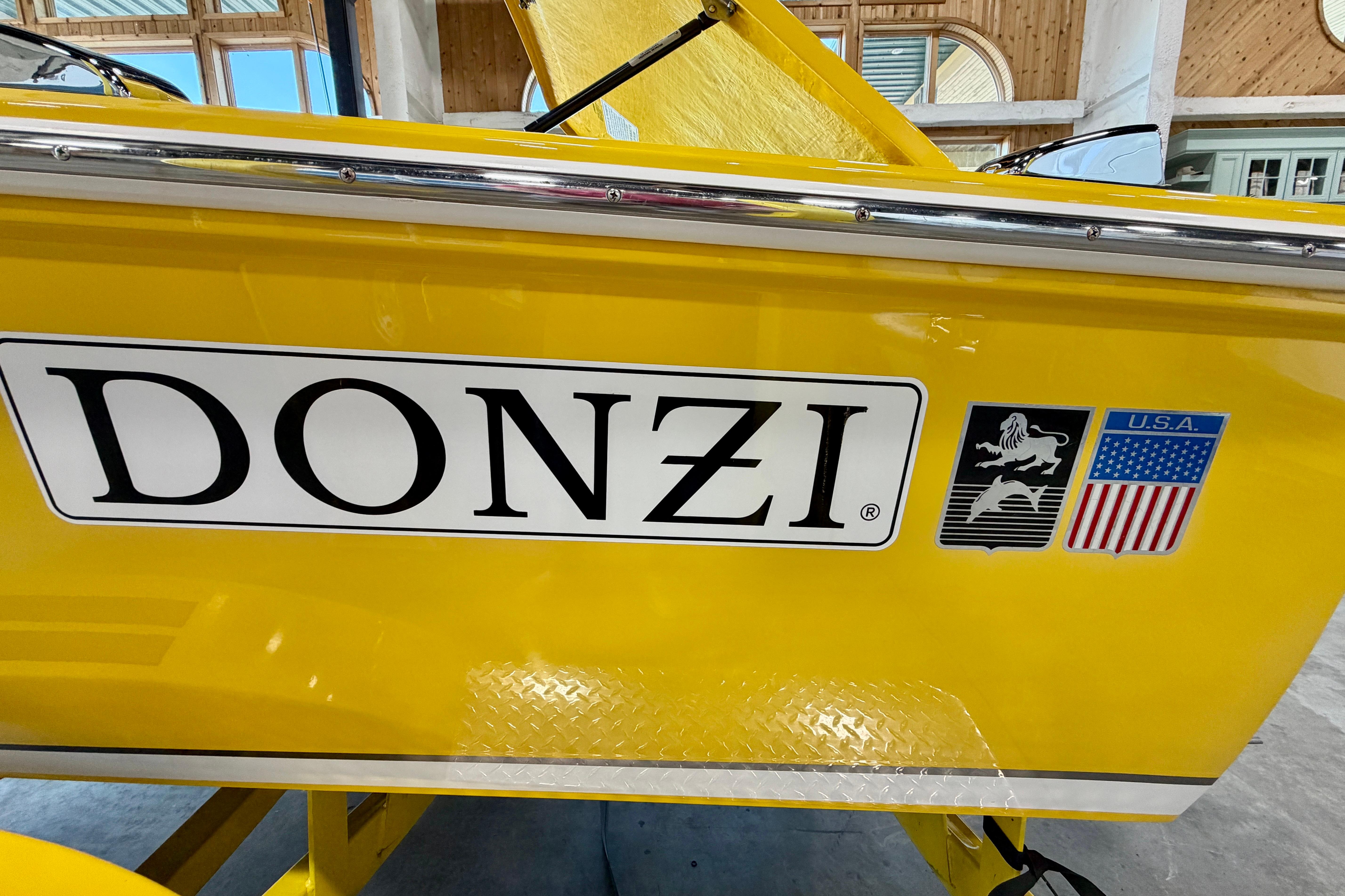Yellow 2004 Donzi 22 Classic boat with logo and USA flag emblem.