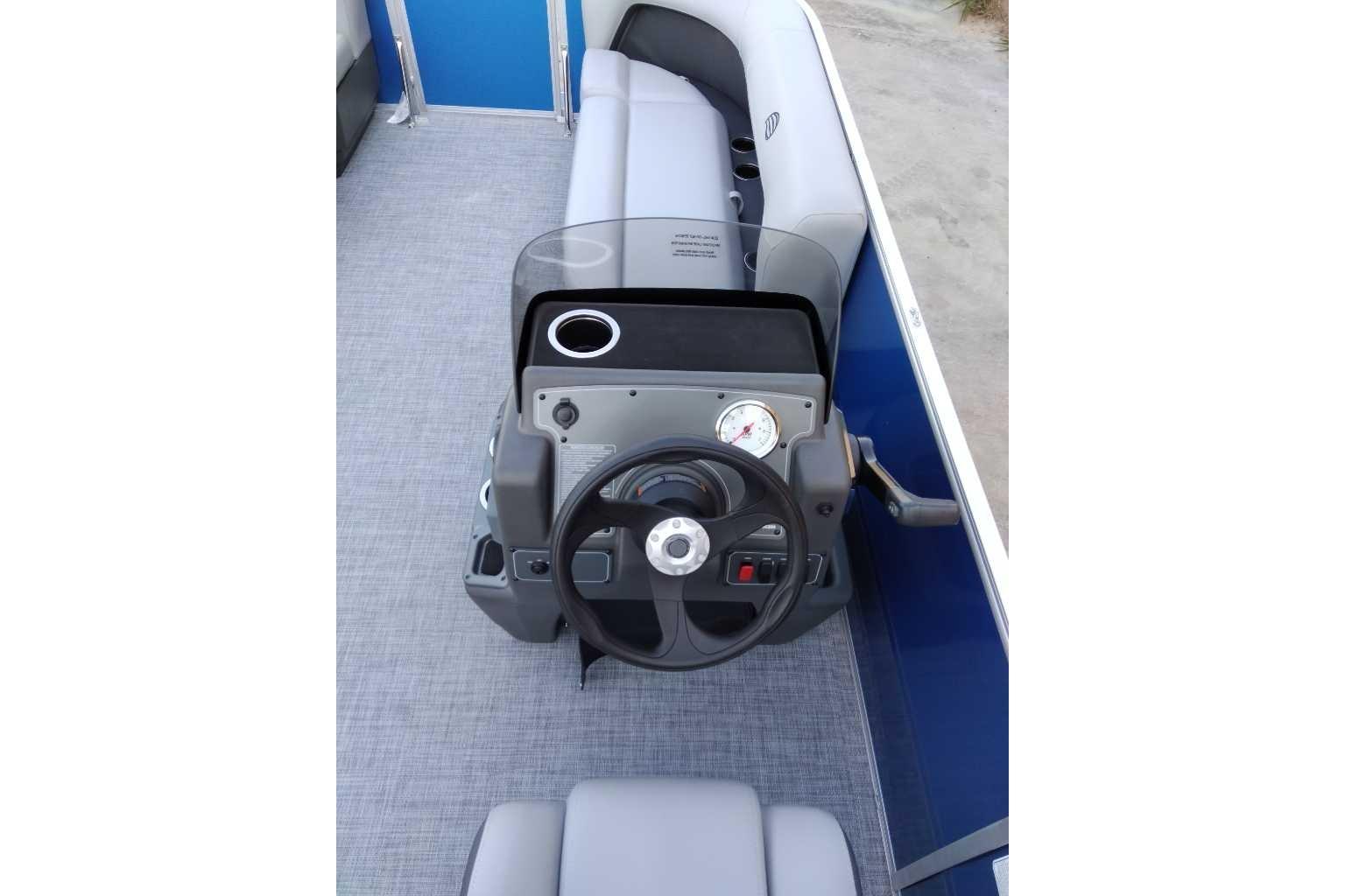 2026 Sun Tracker Party Barge 16 DLX steering console with gray seating and blue accents.