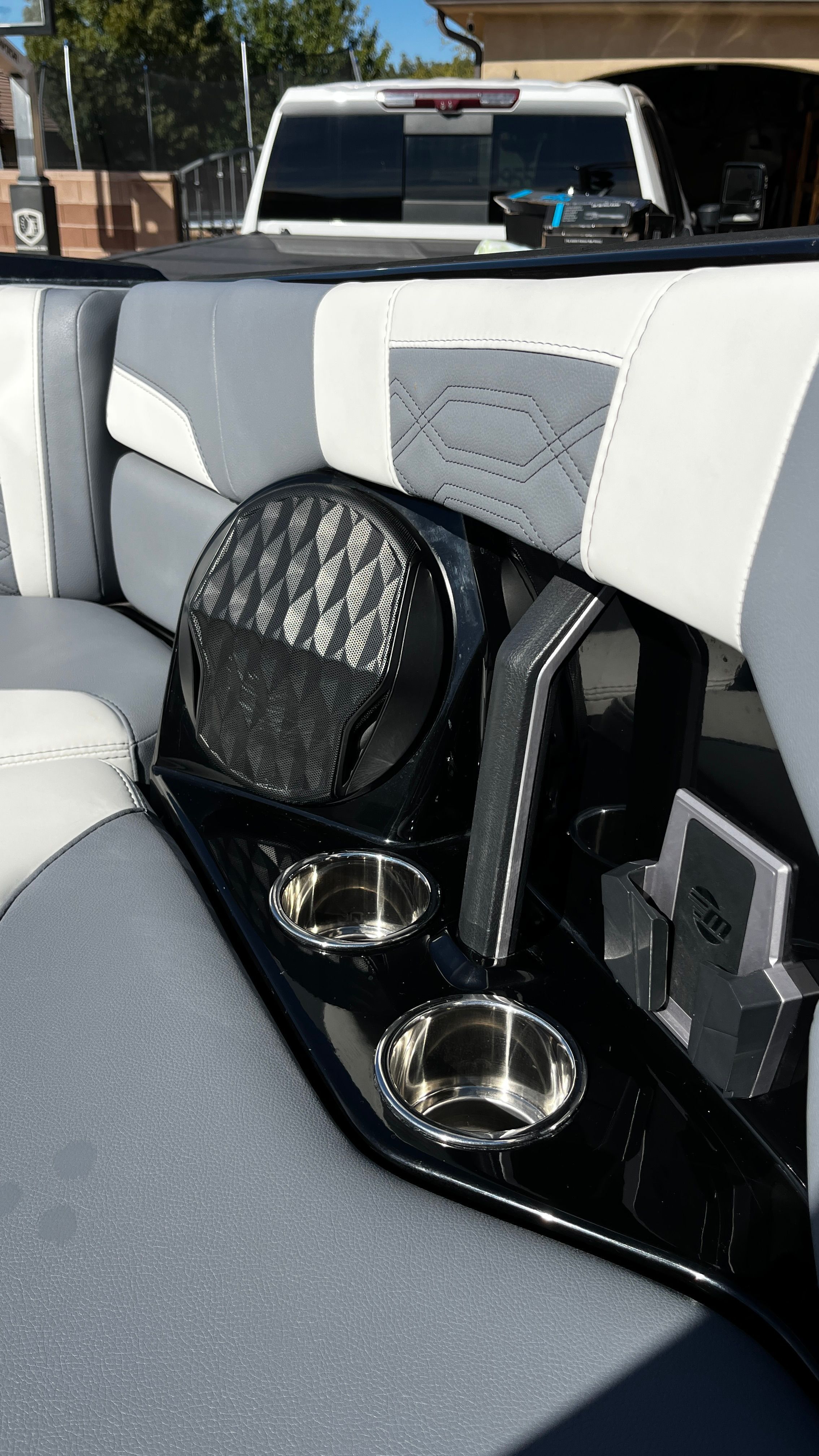 Interior of a Malibu Wakesetter 26 LSV with gray and white seats, cup holders, and speaker.