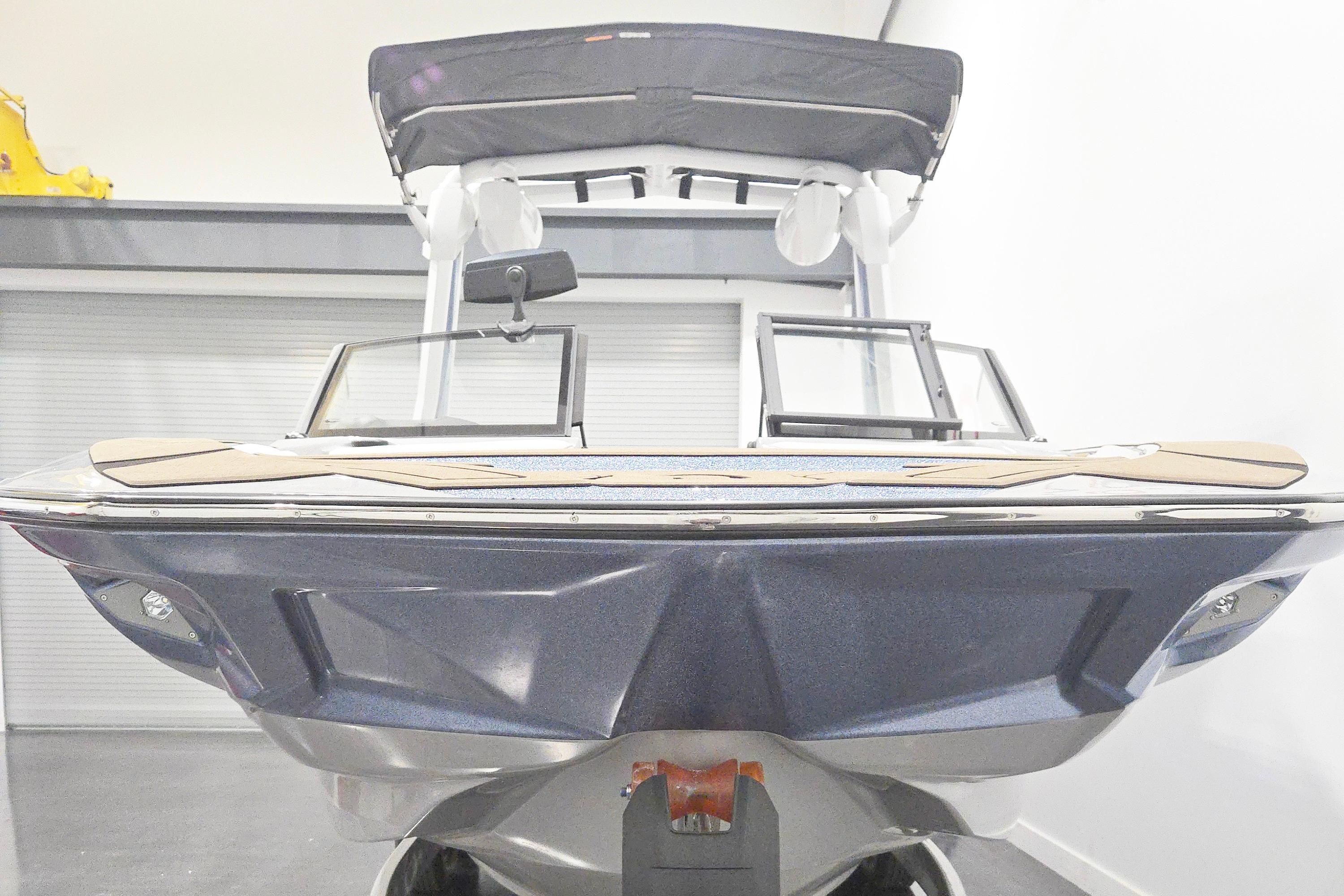 2026 Centurion Nv243 boat in showroom, front view with sleek design and canopy.