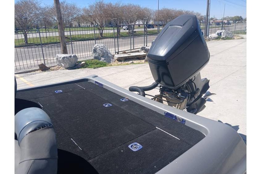 1994 Gambler 21 boat with outboard motor, parked outdoors on a sunny day.