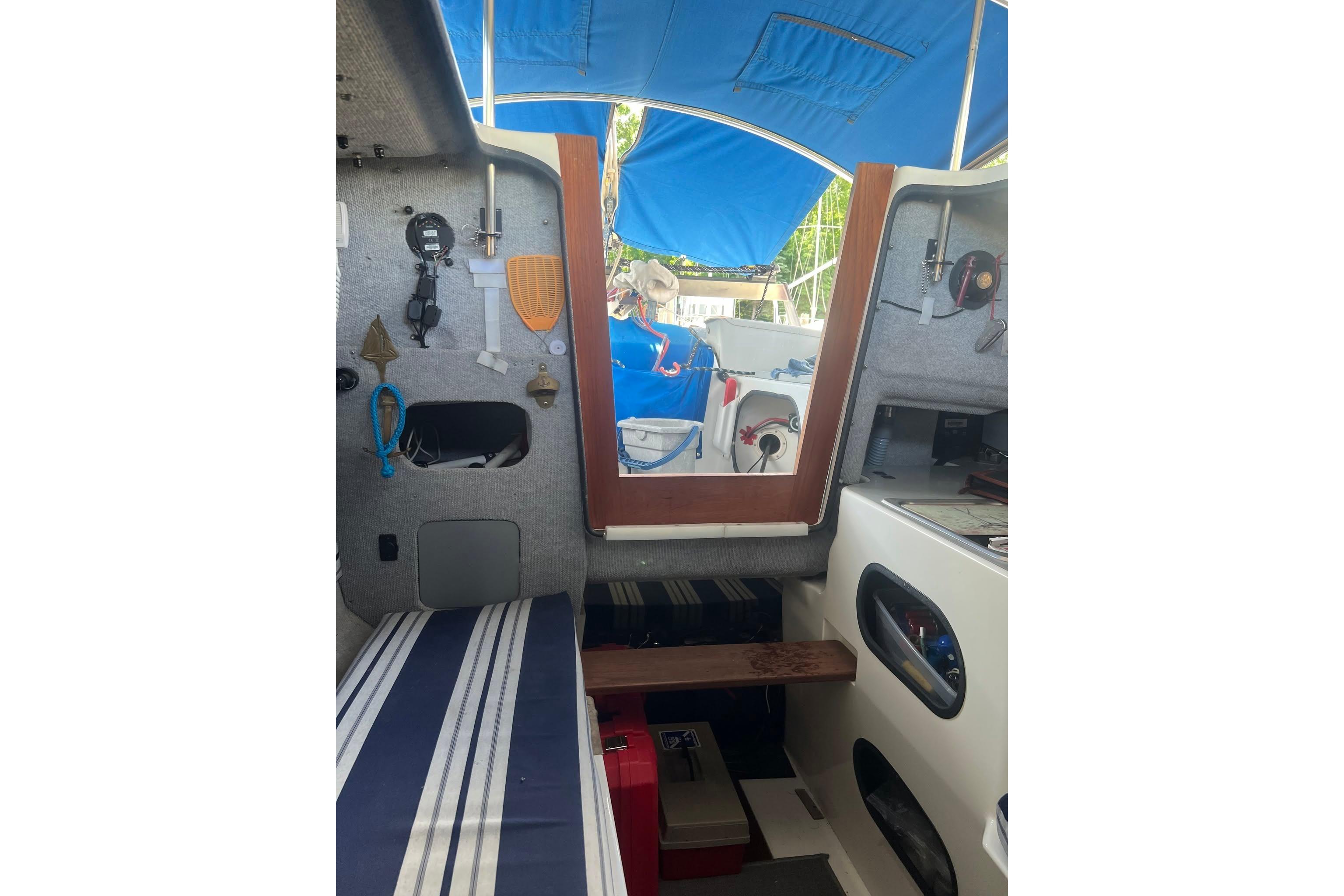 Interior of 1993 Corsair F-27 sailboat with blue canopy and striped seating.