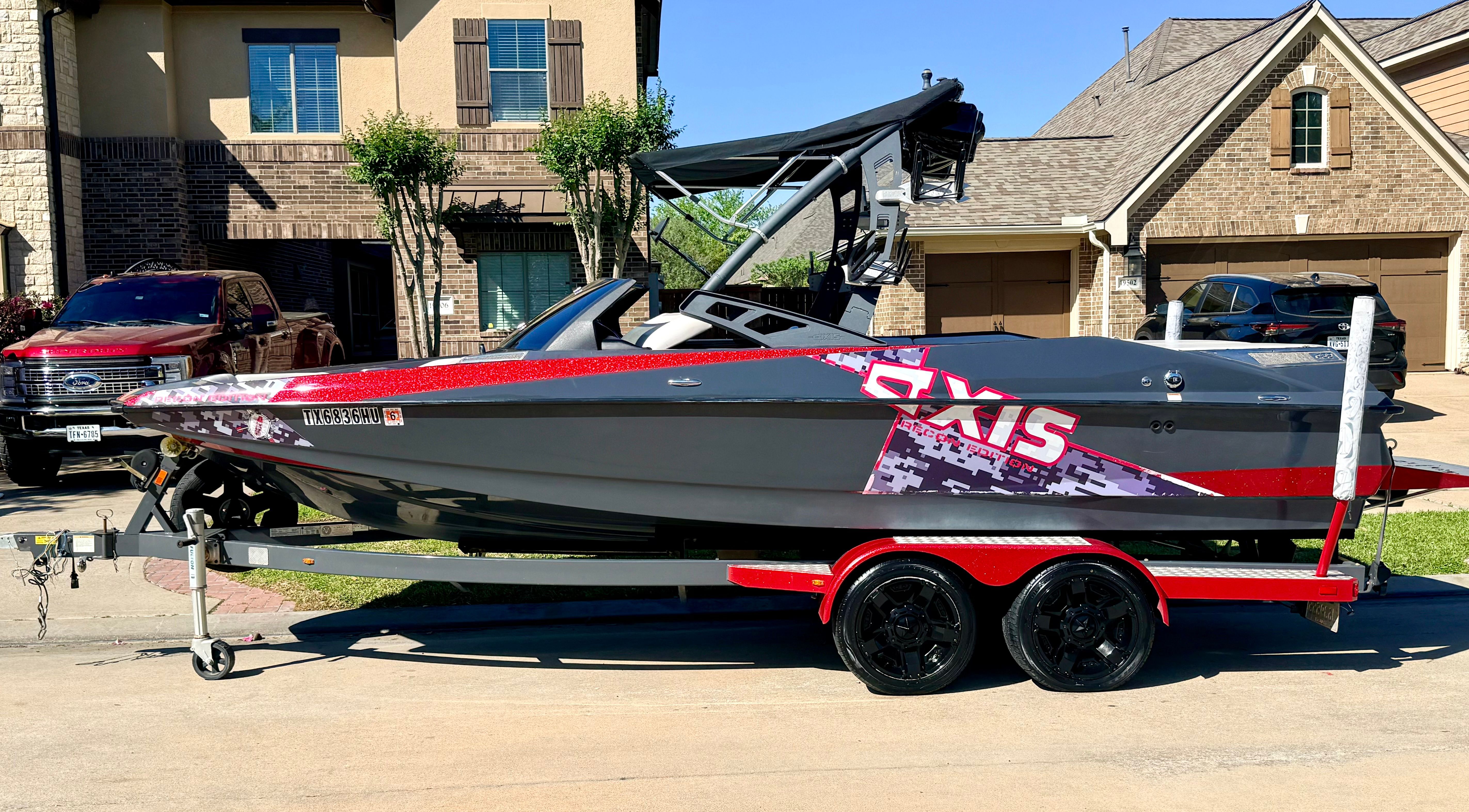 2013 Axis A22 boat on trailer parked in residential area.
