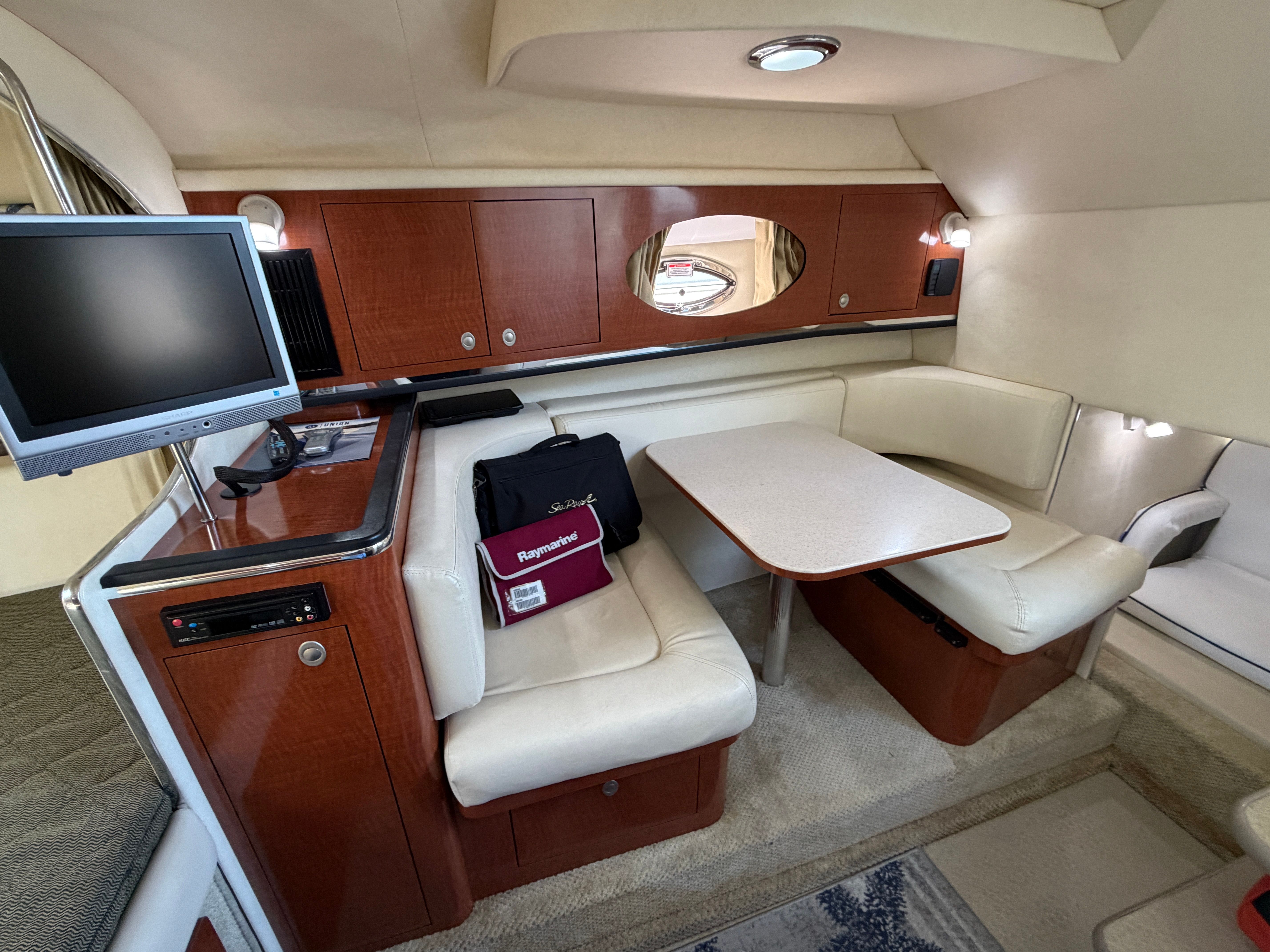 Interior of 2005 Sea Ray 290 Amberjack with dining area and TV.