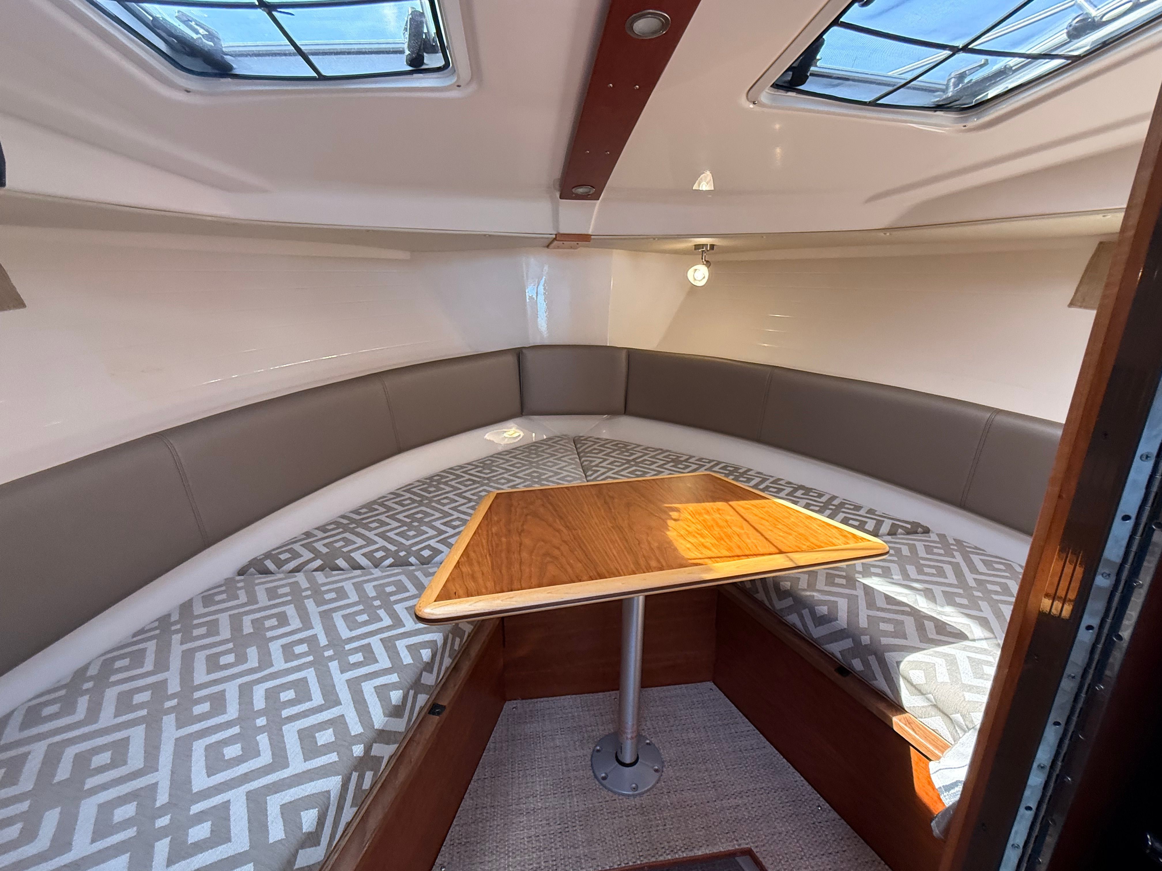 Interior of the Cutwater C-228 with cushioned seating and a wooden table.