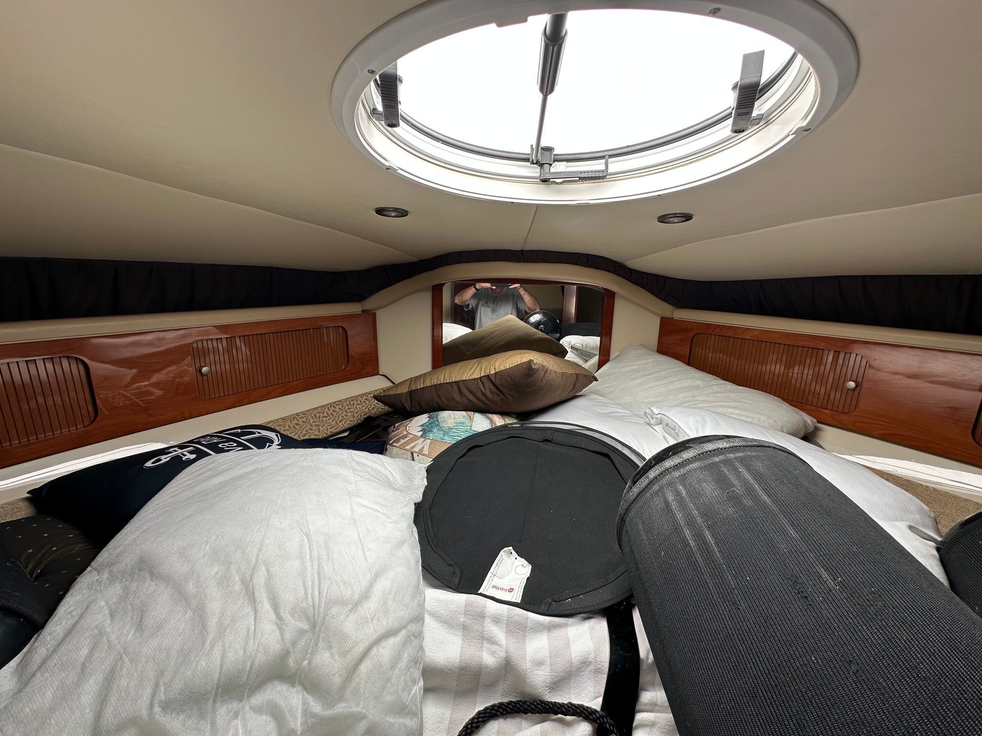 Interior of a cabin with a bed and skylight on a boat.