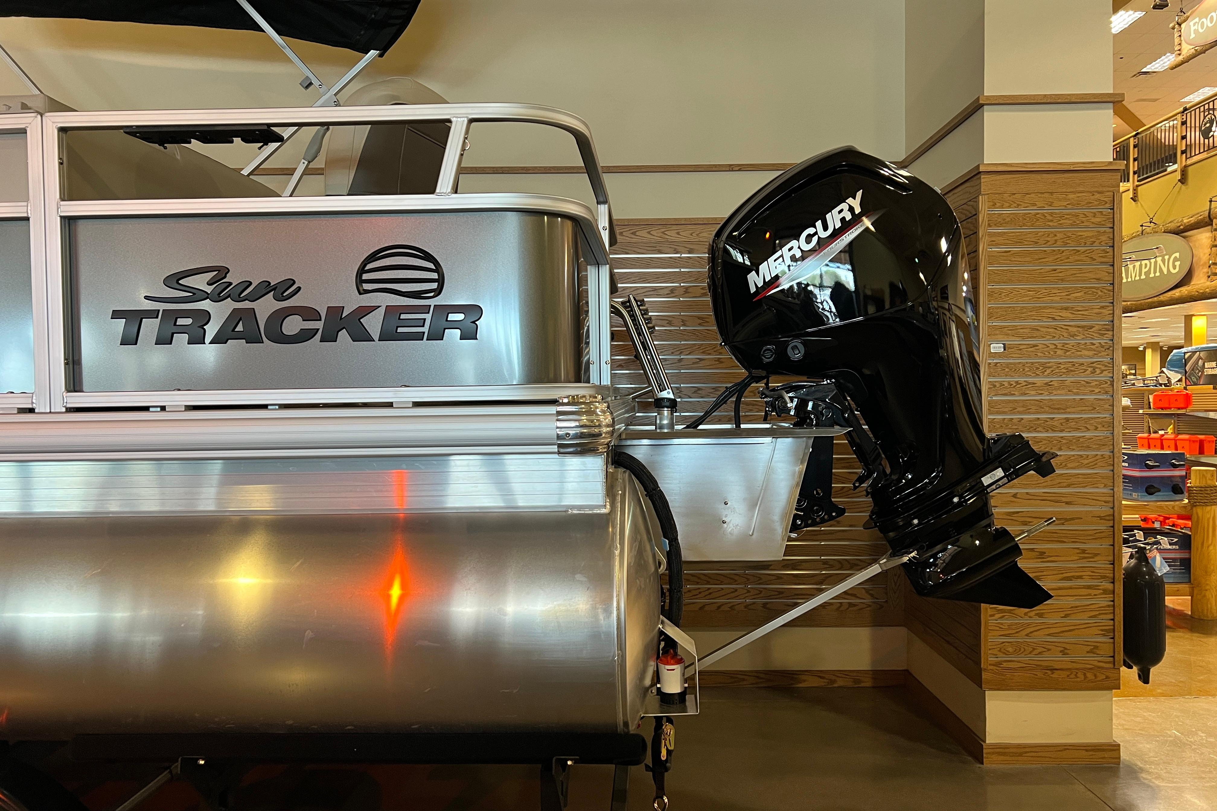 2026 Sun Tracker Bass Buggy 18 DLX with Mercury outboard motor displayed indoors.
