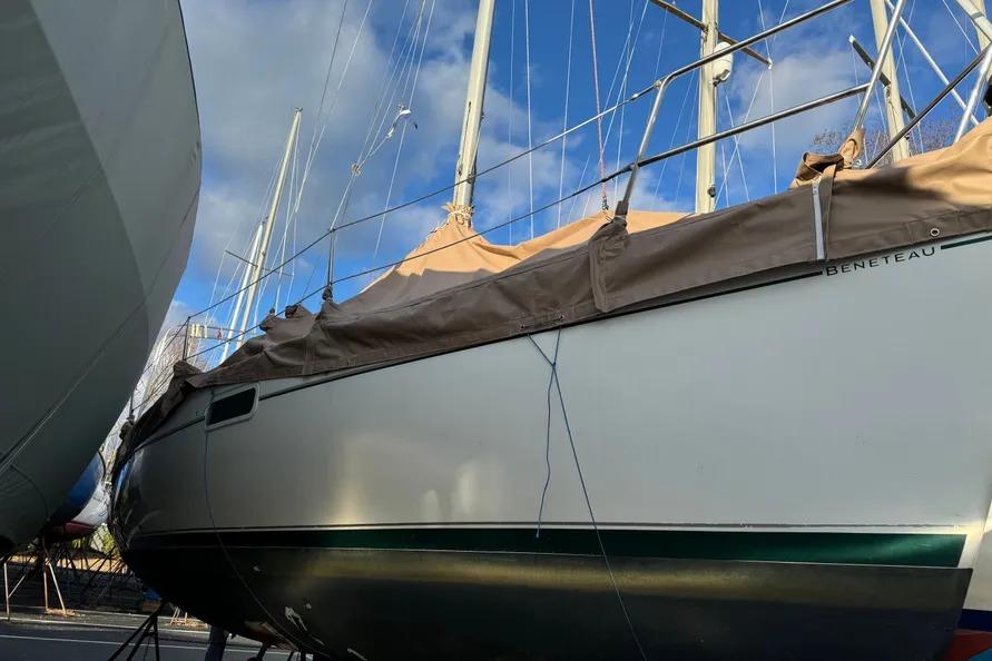 Beneteau Oceanis 321 sailboat from 2000, docked with protective cover, under a clear sky.