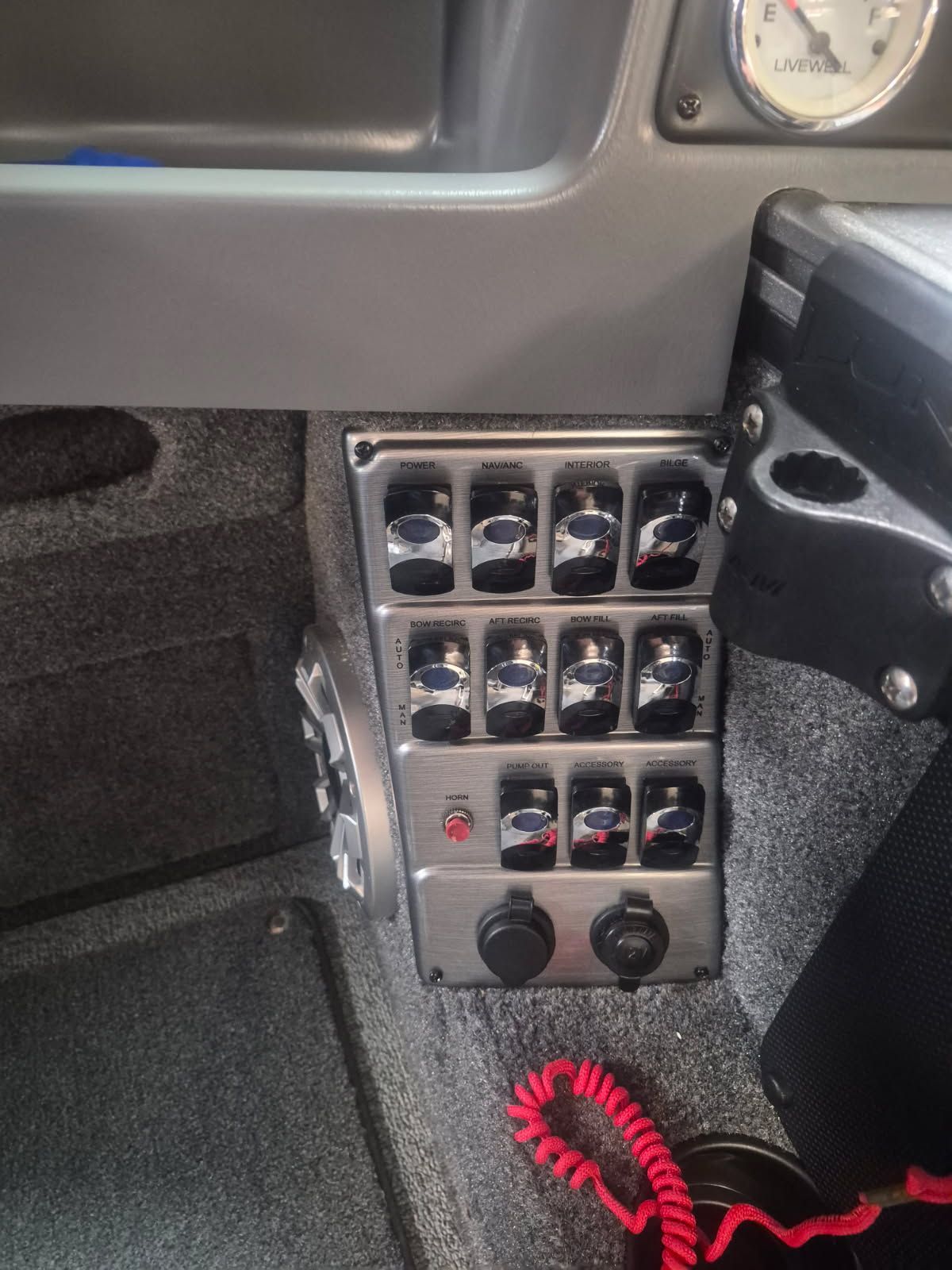 Close-up of a boat's control panel with multiple switches and a red cord.