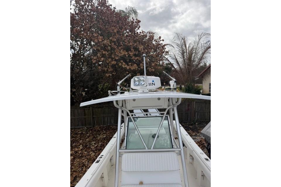 2002 Regulator 26 Forward Seating boat with T-top and radar, parked outdoors.