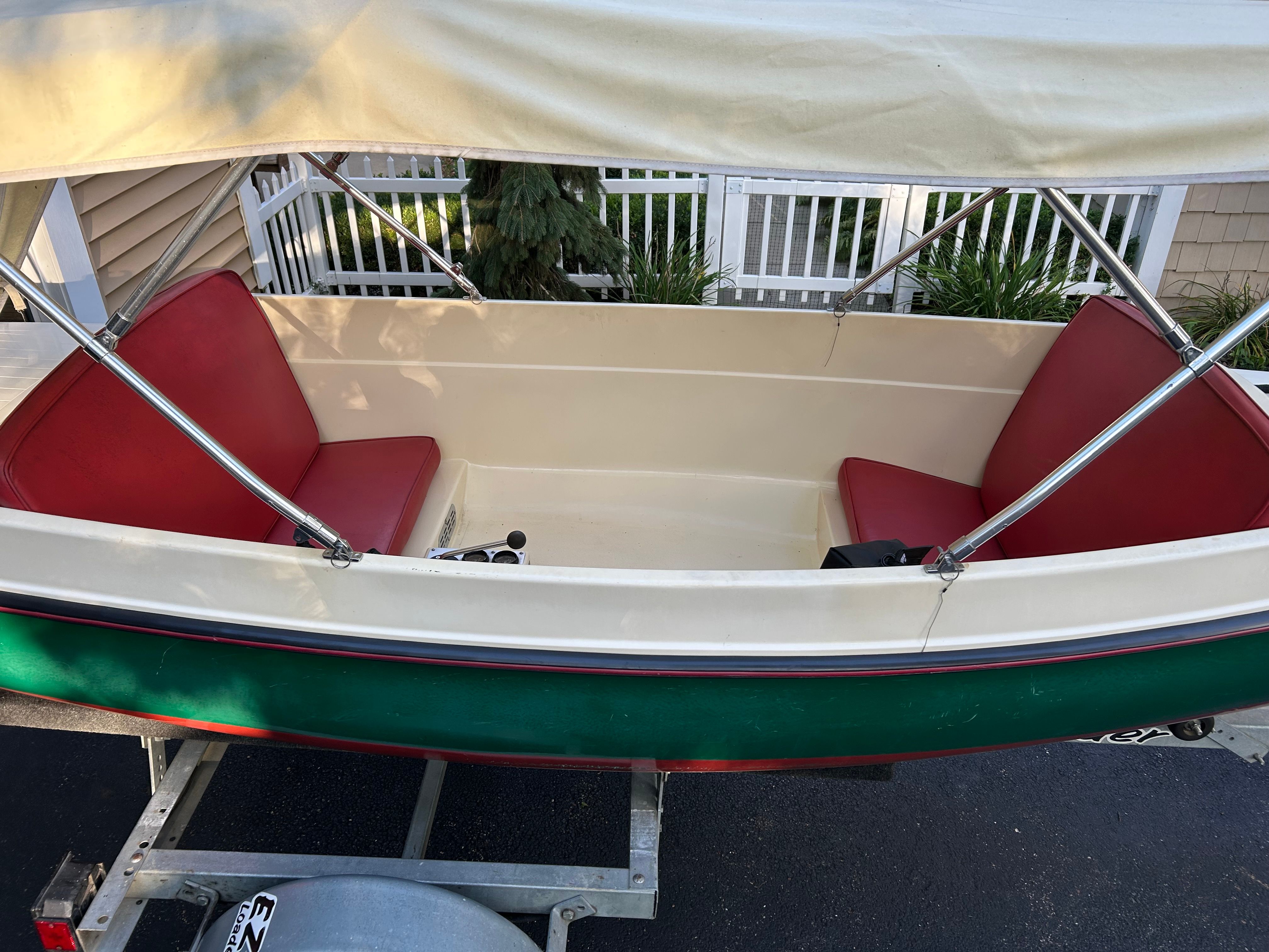 1995 Elco Launchboat with red seats and canopy on trailer.