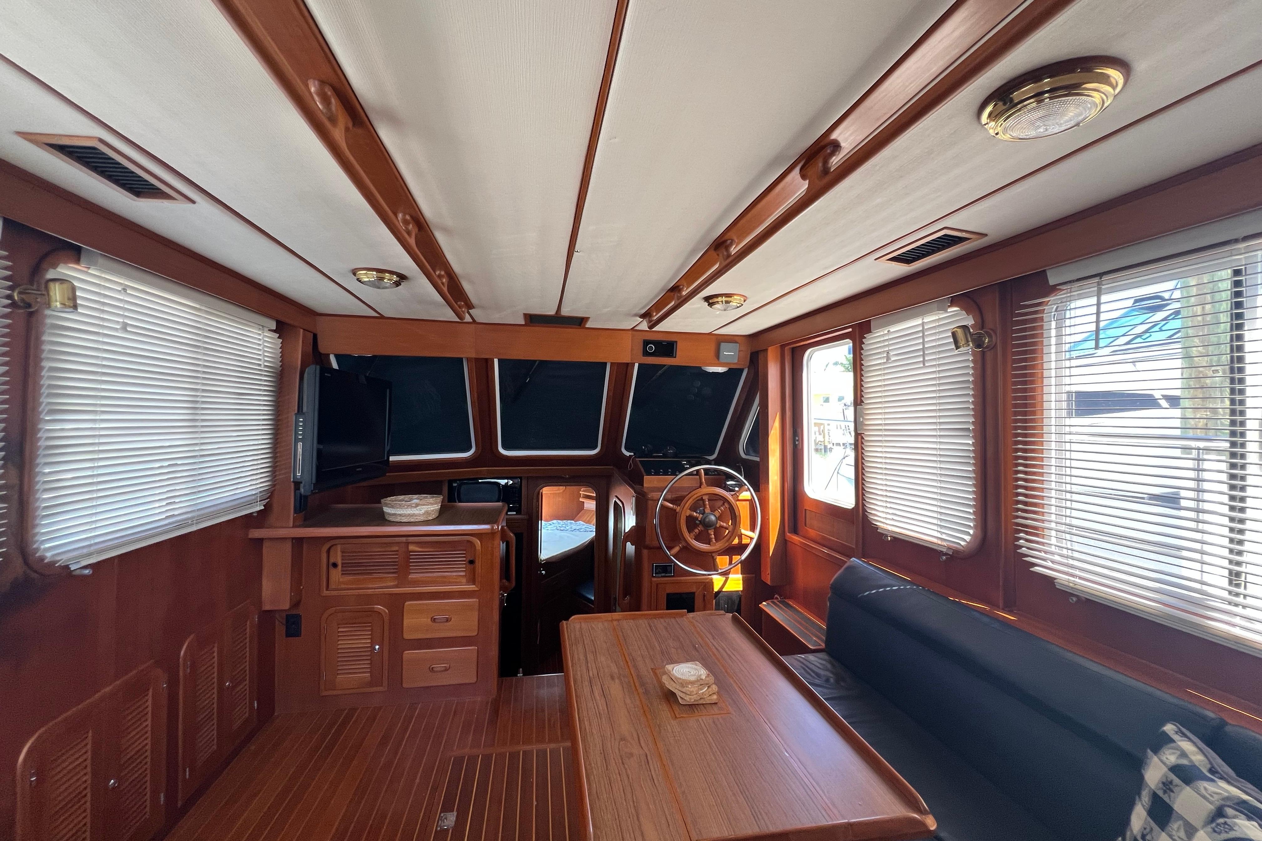 Interior of 2007 Heritage East 36 Sundeck Trawler with wooden furnishings and helm station.
