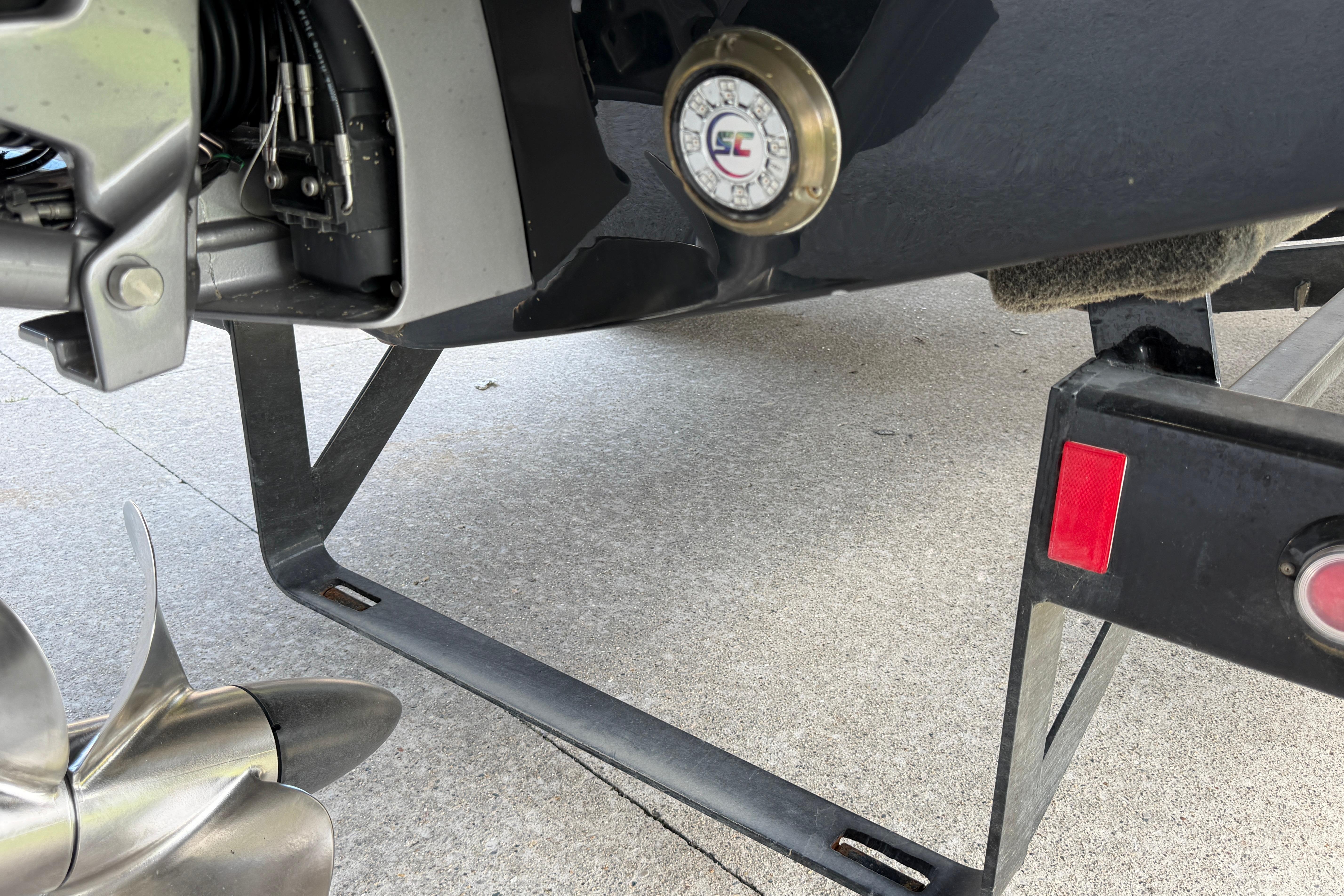 Close-up of a 2021 Cobalt R8 Surf boat's propeller and trailer detail.