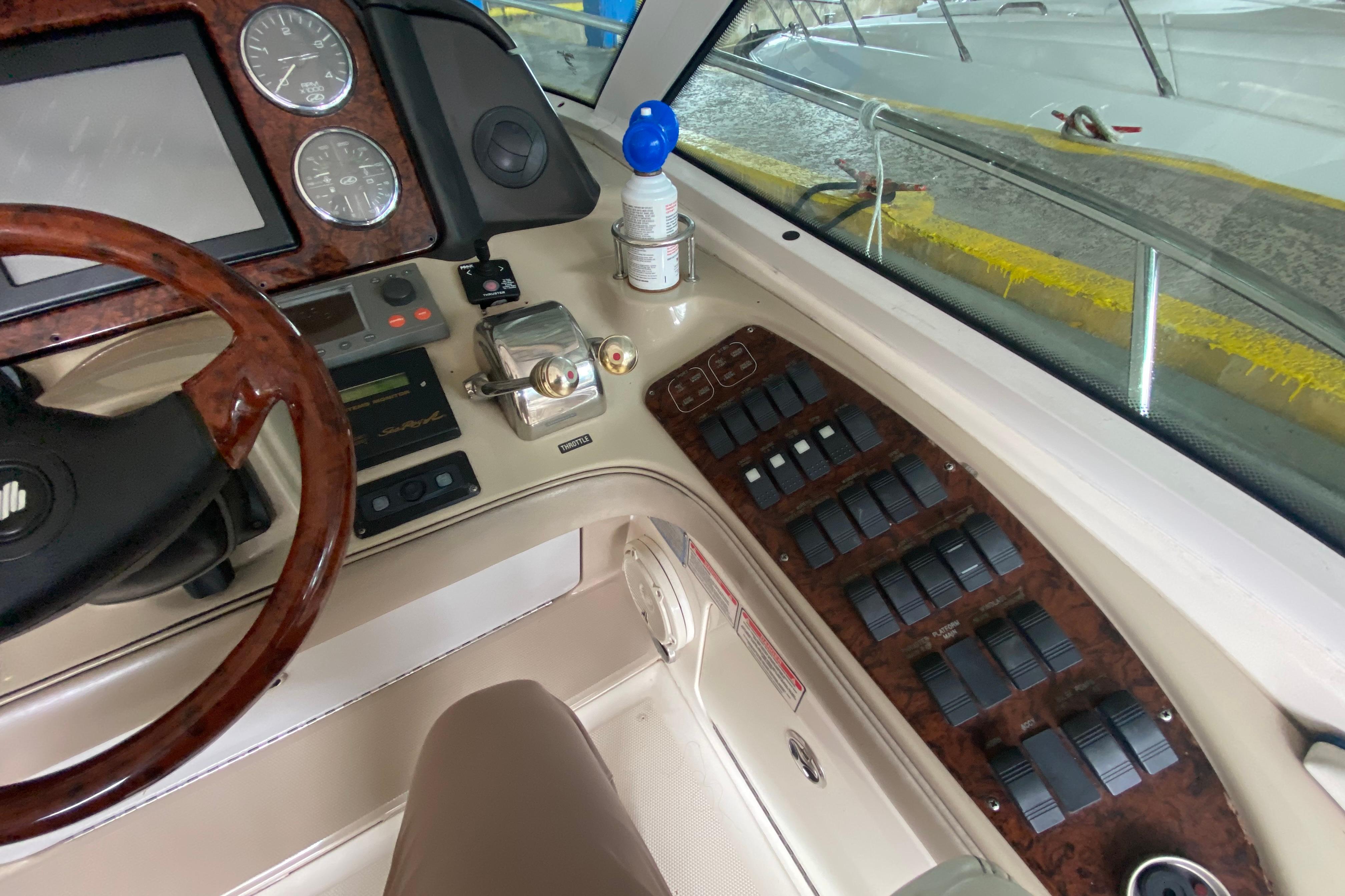Helm of 2005 Sea Ray 500 Sundancer with wood accents and control panels.