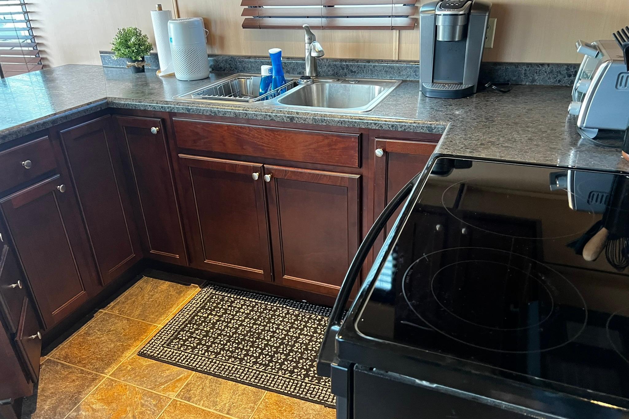 Modern kitchen on 2010 Skipperliner 480 Flybridge with dark wood cabinets and appliances.
