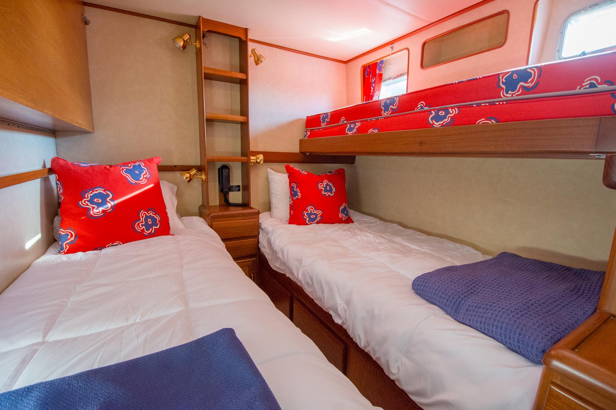 Cozy cabin interior of 2000 Fleming 55 yacht with twin beds and vibrant decor.