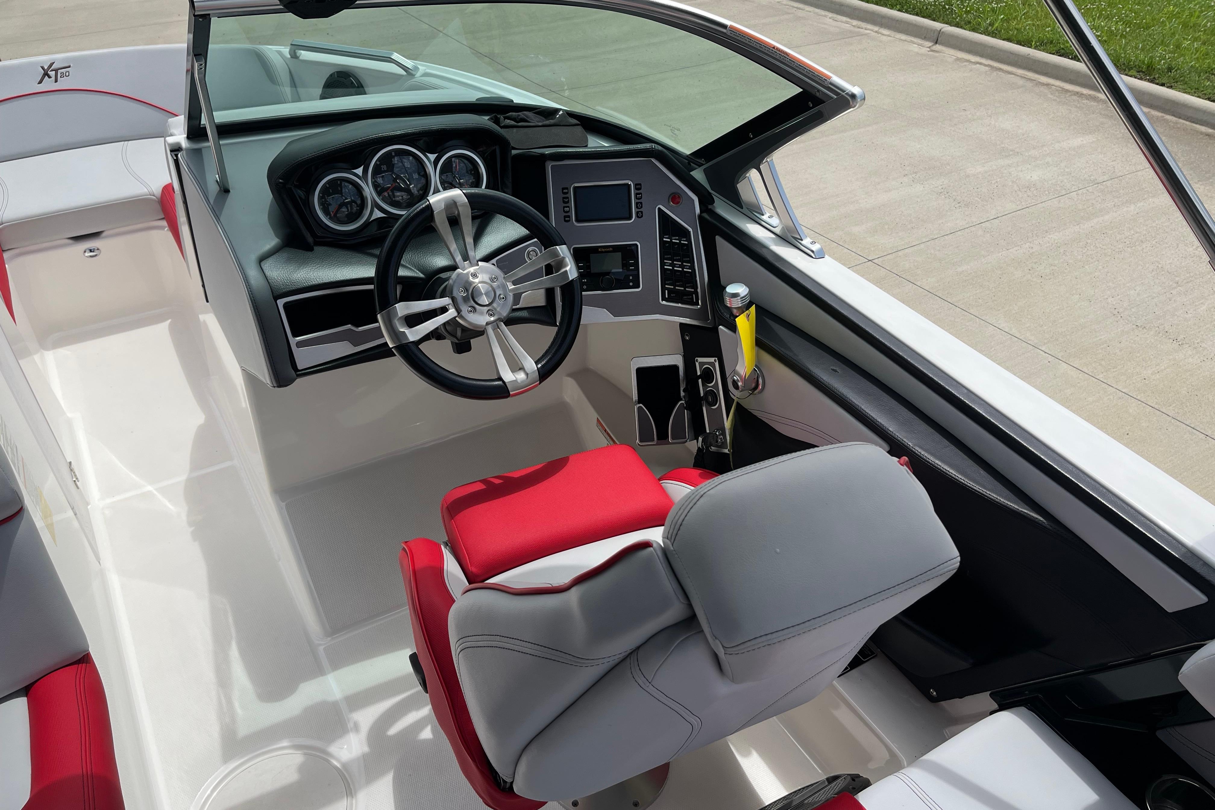 2019 MasterCraft XT20 boat interior with modern dashboard and red-gray seating.