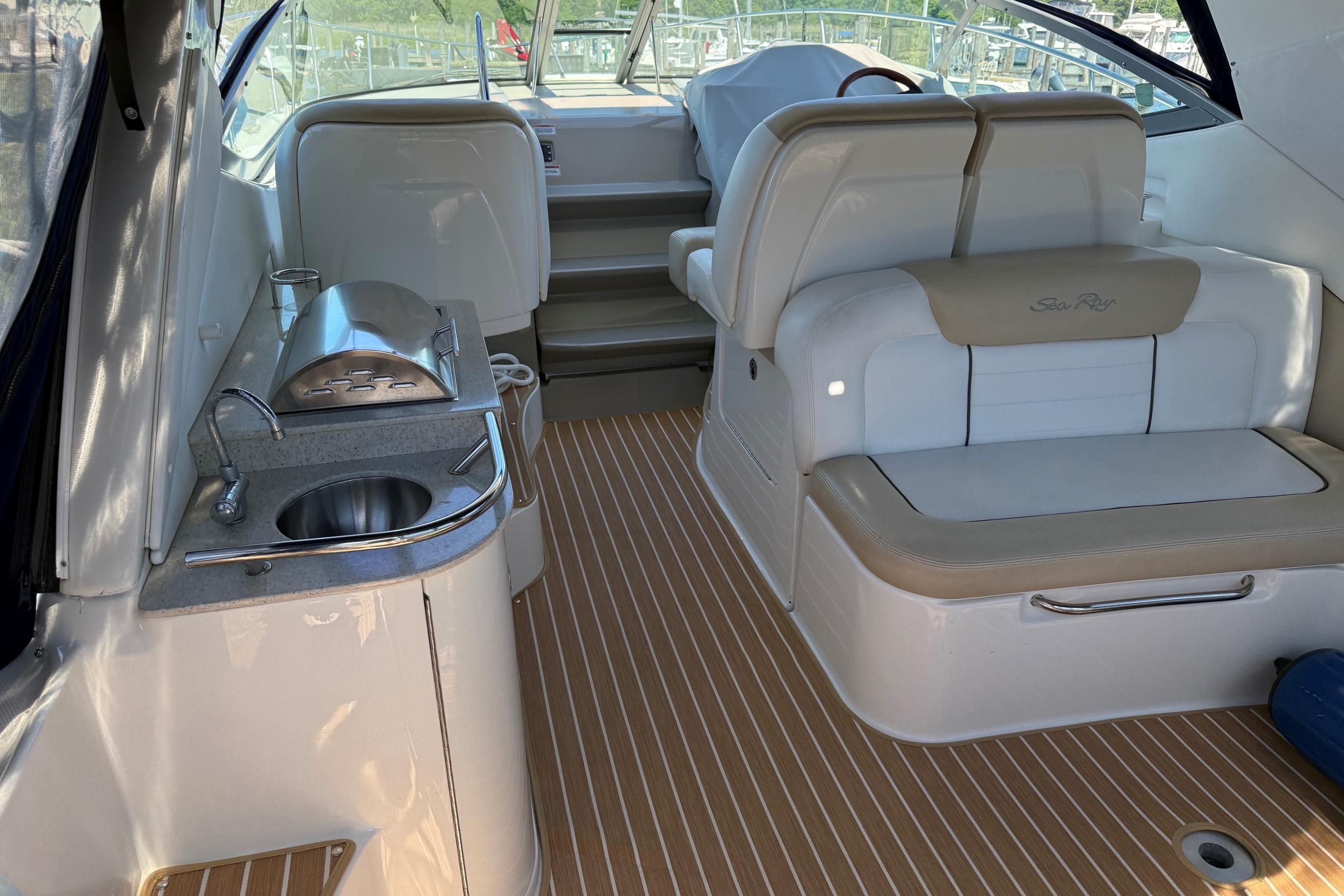 2008 Sea Ray Sundancer 330 interior with seating, sink, and grill on deck.