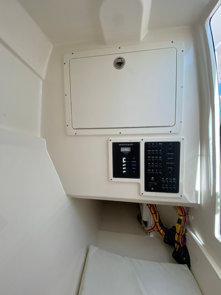 Interior of 2023 Cobia 330 with control panel and storage.