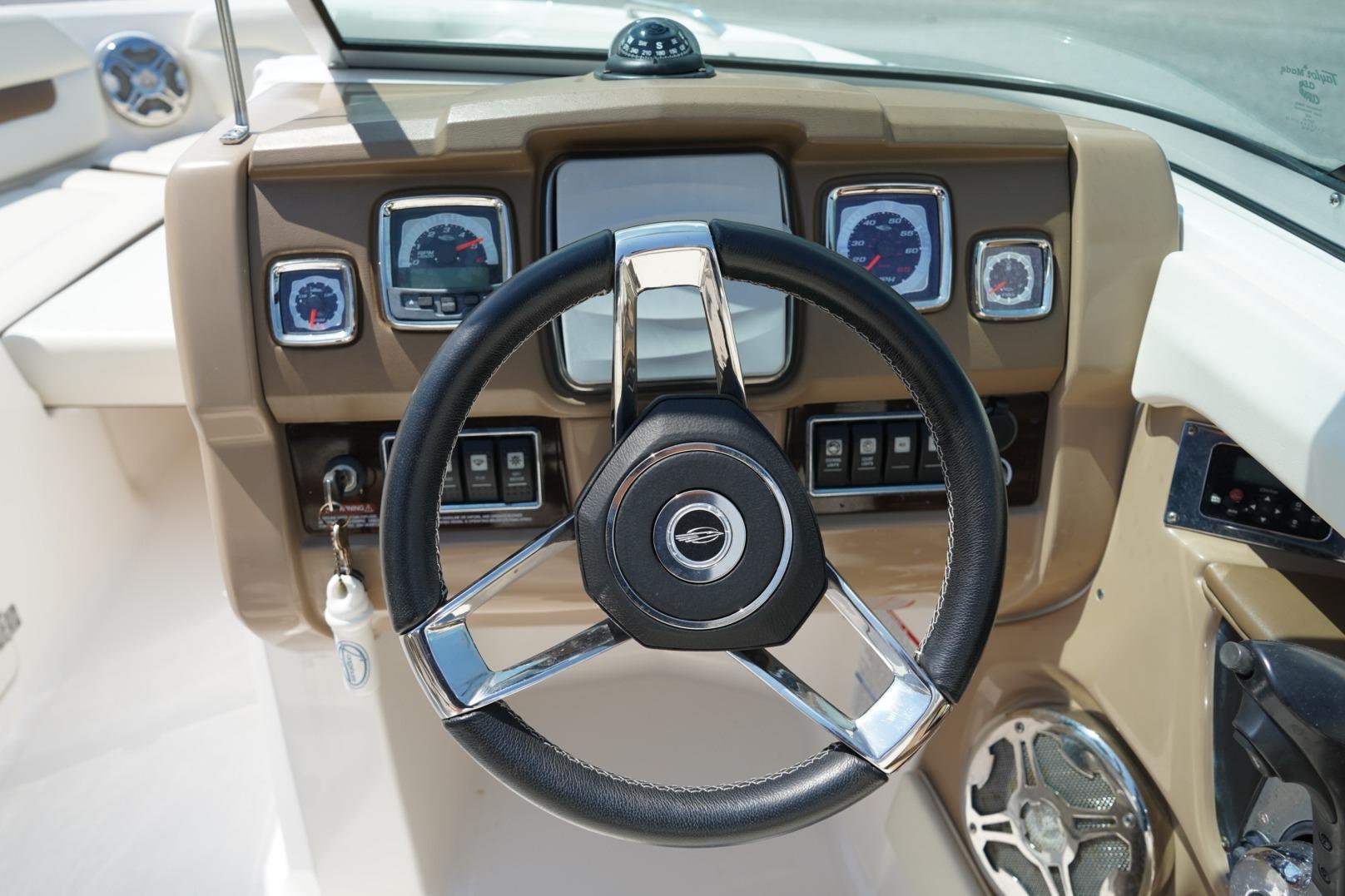 Steering wheel and dashboard of 2013 Chaparral 206 SSi boat, featuring gauges and controls.