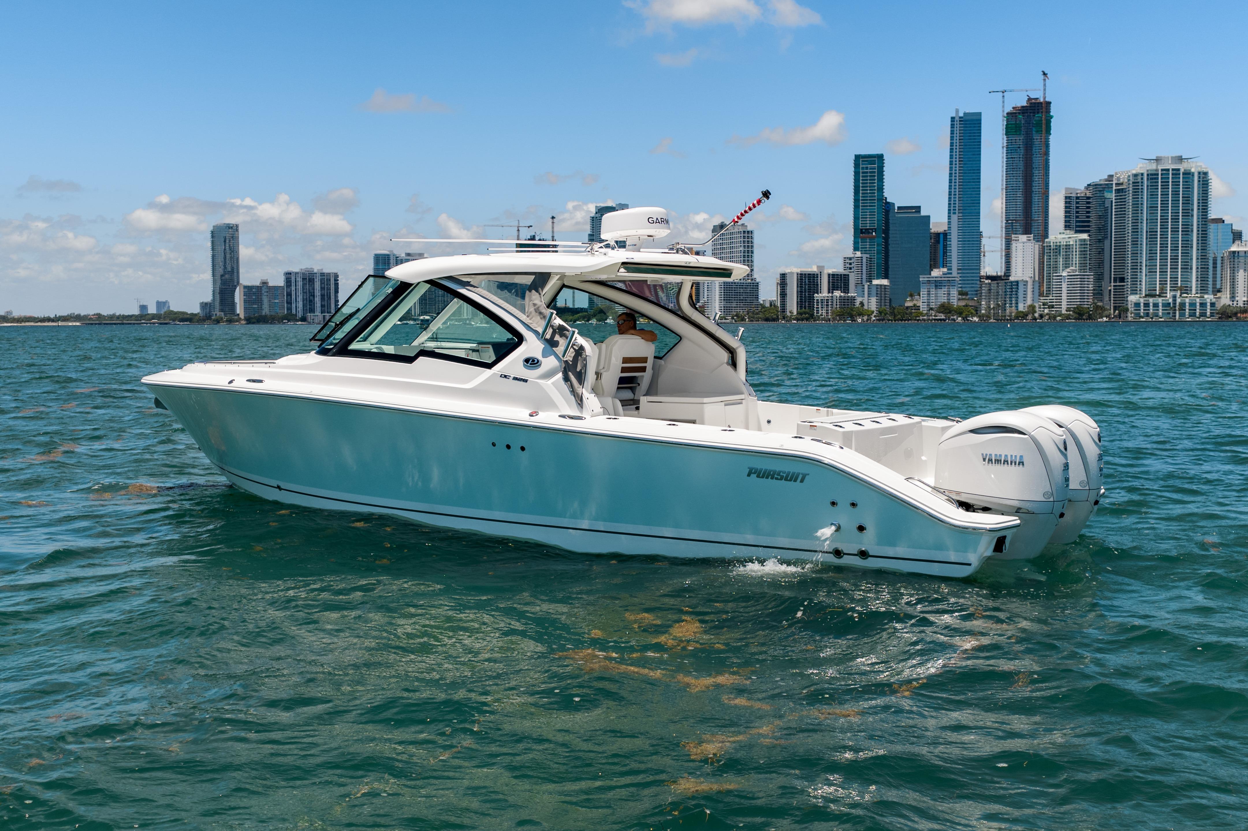 2026 Pursuit DC 326 Dual Console boat cruising near city skyline.
