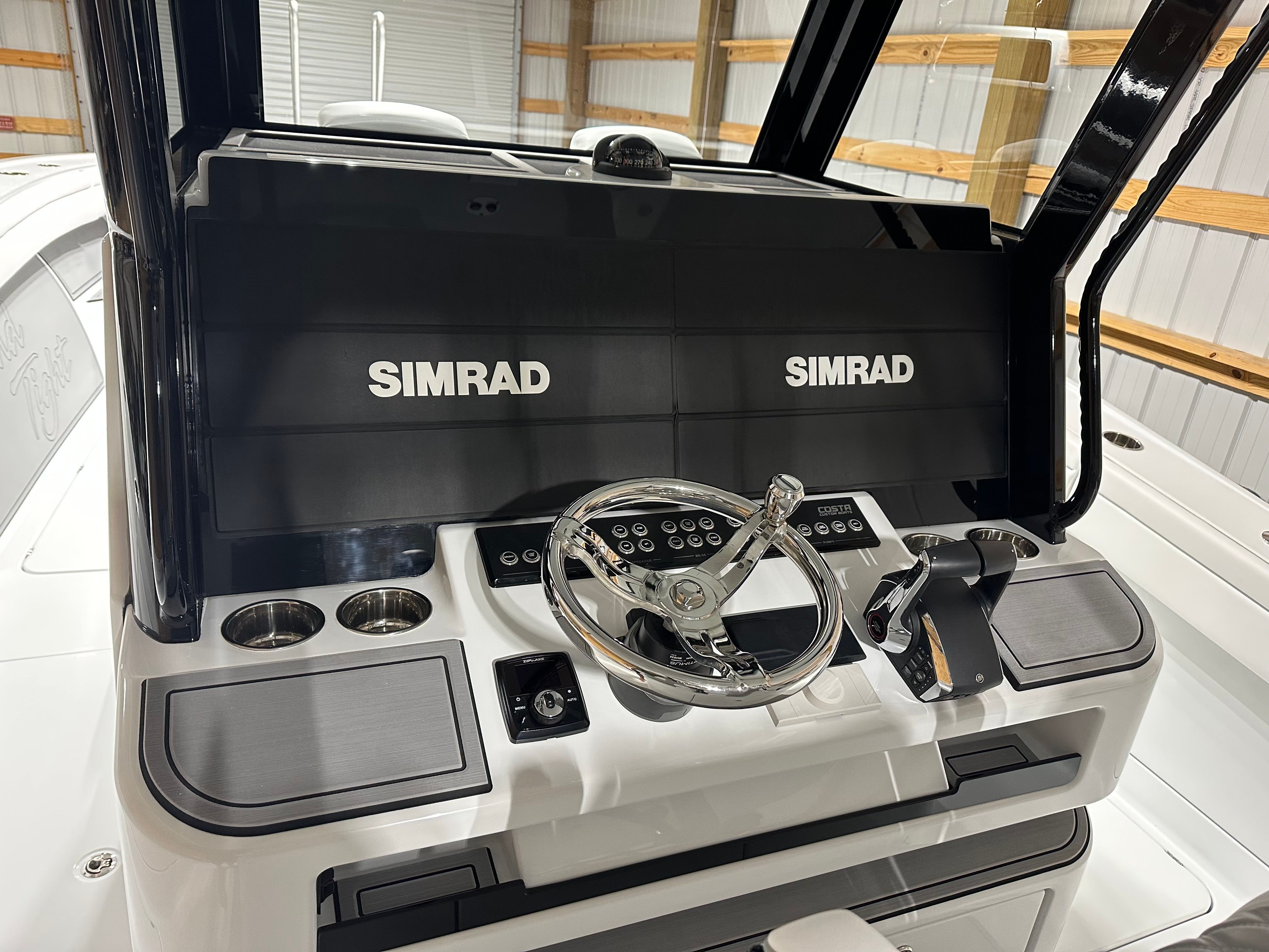 The cockpit of a Costa Custom Boats 34SV with Simrad screens and controls.