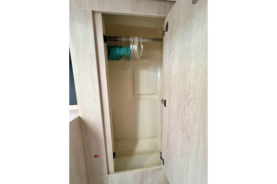 Empty wooden closet with hangers inside a 2017 Leopard 40 model.