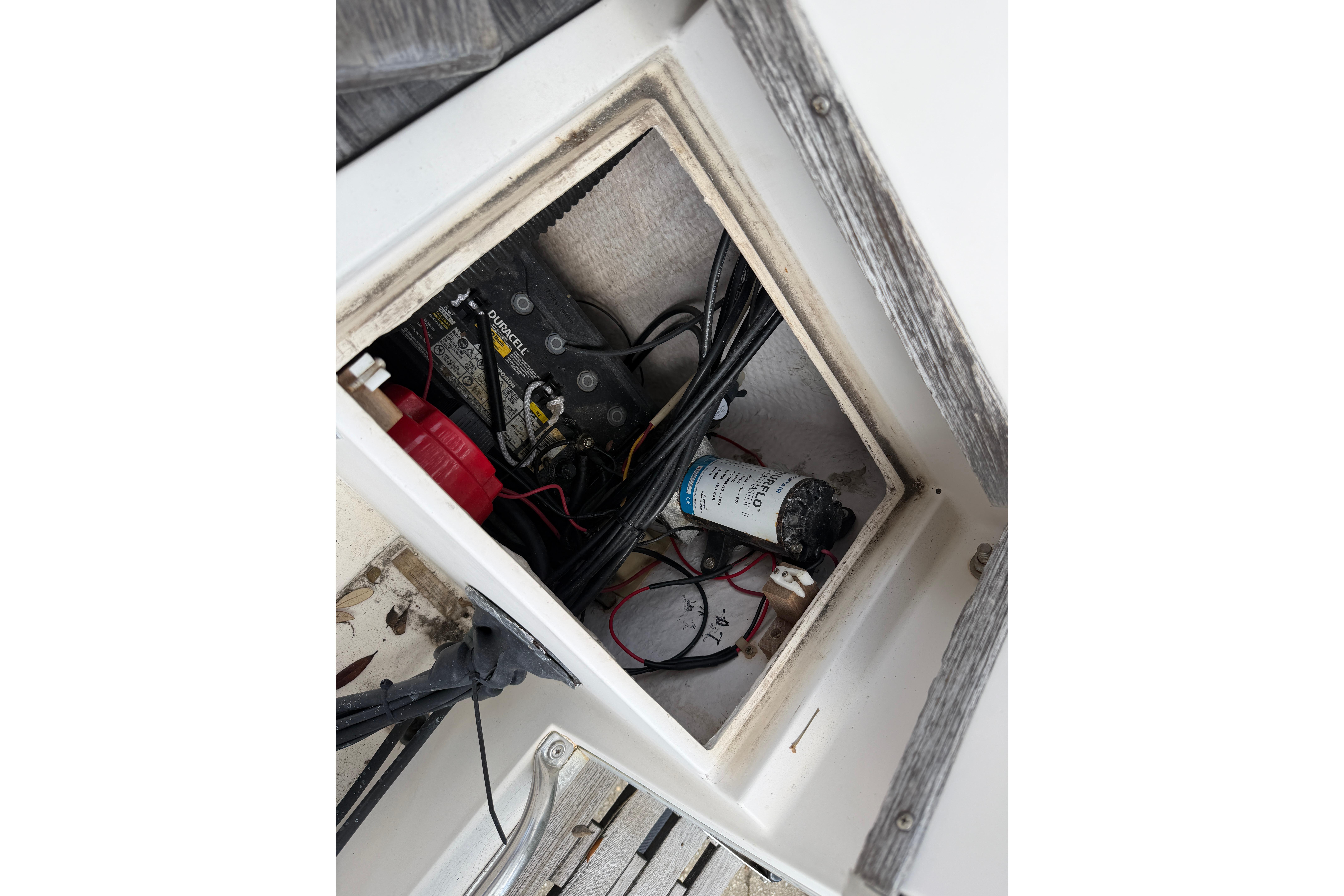 Battery compartment of a 1987 Grady-White Seafarer 226 boat, showing wiring and components.