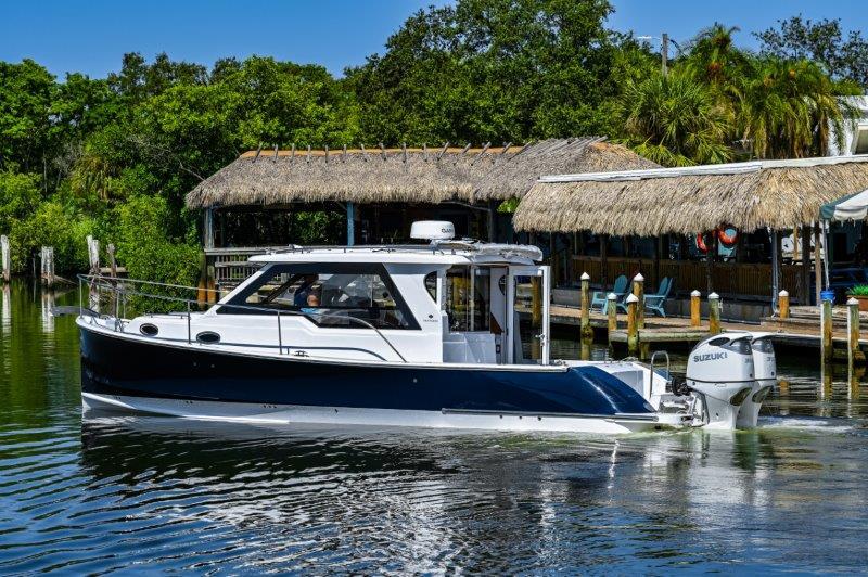 2024 True North 34 boat cruising near a tropical dock.