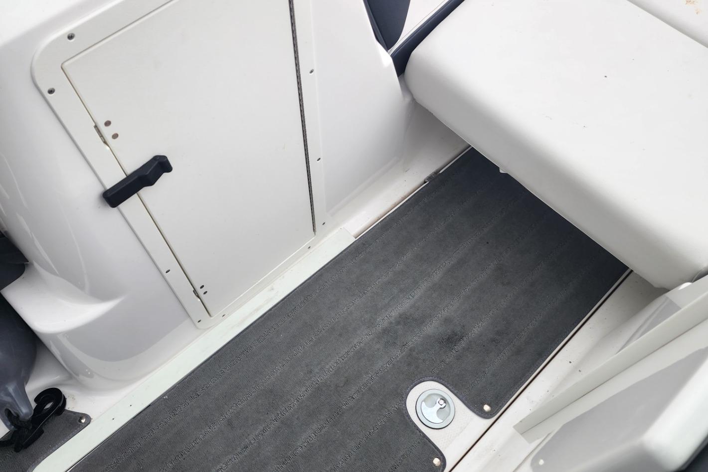 Interior view of a 2015 Yamaha Boats 212X, featuring seating and storage compartment.