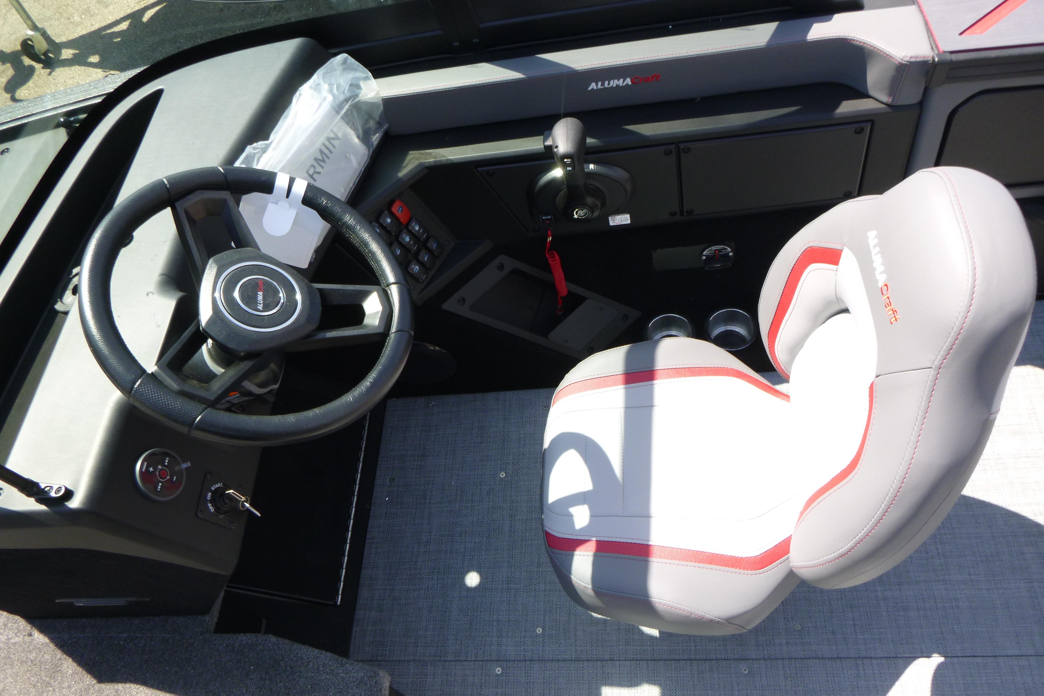 2025 Alumacraft Trophy 185X Sport boat cockpit with steering wheel and cushioned seat.