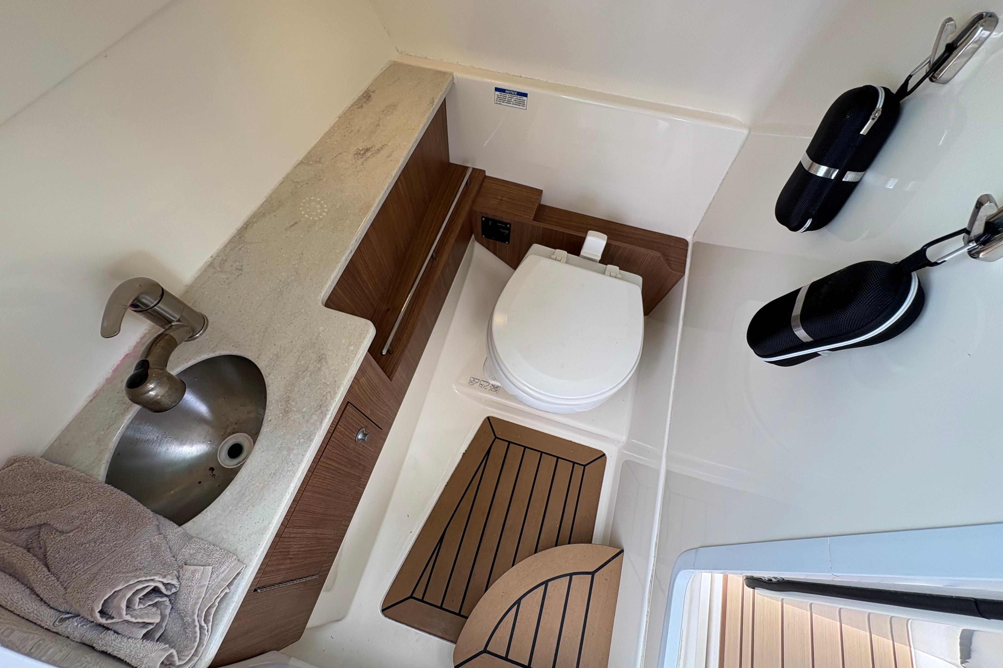 2017 Boston Whaler 270 Vantage boat bathroom with sink, toilet, and storage.