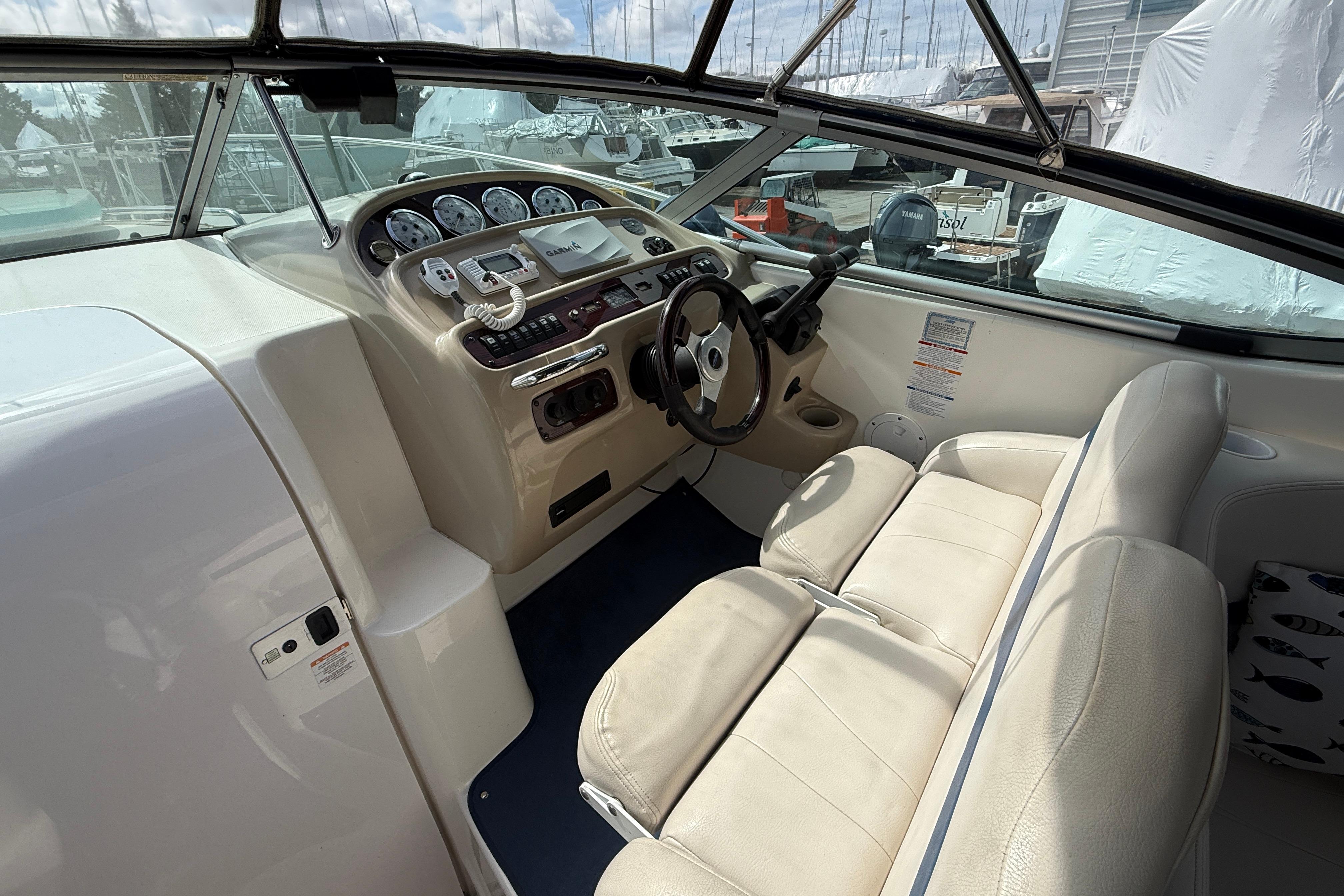 2003 Chaparral Signature 280 boat cockpit with steering wheel and control panel.