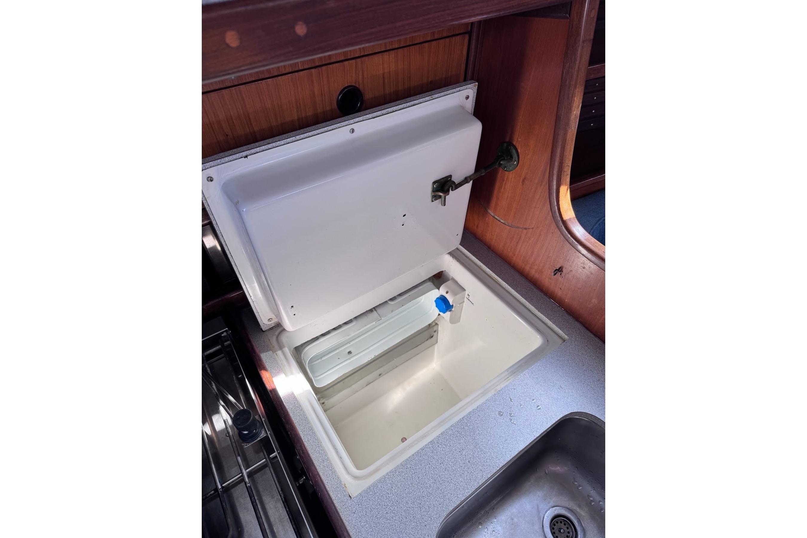 Interior view of 1985 Beneteau First 375 yacht's galley with open storage compartment.
