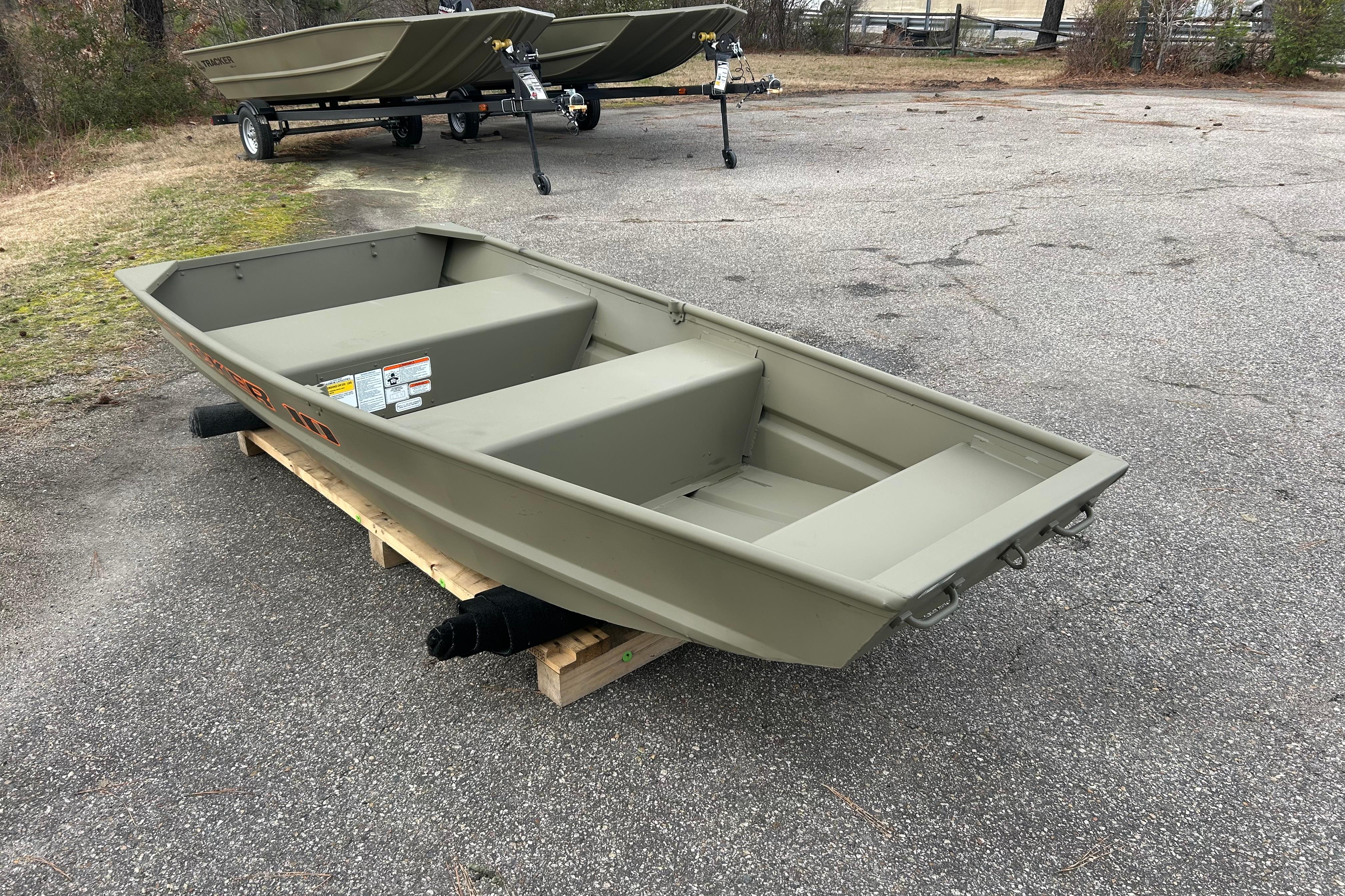 2026 Tracker Grizzly 10 Jon boat on wooden pallet, parked outdoors on asphalt.
