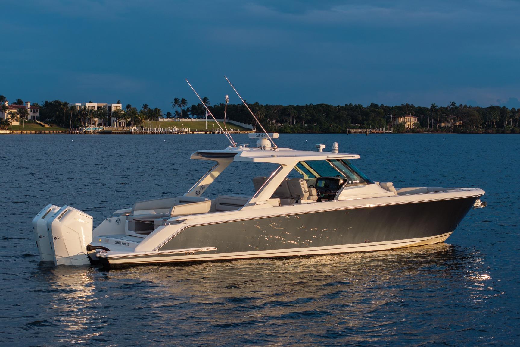 2022 Tiara Sport 43 LS luxury boat on calm water at sunset.