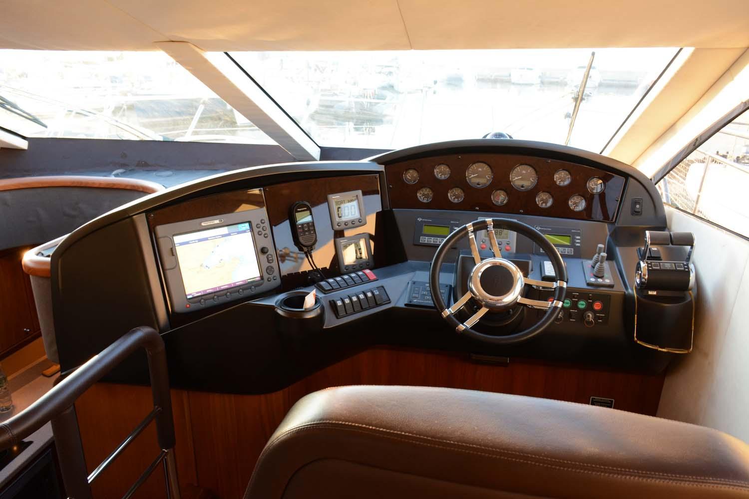 Helm of 2009 Sunseeker Manhattan 52 yacht with navigation instruments and steering wheel.