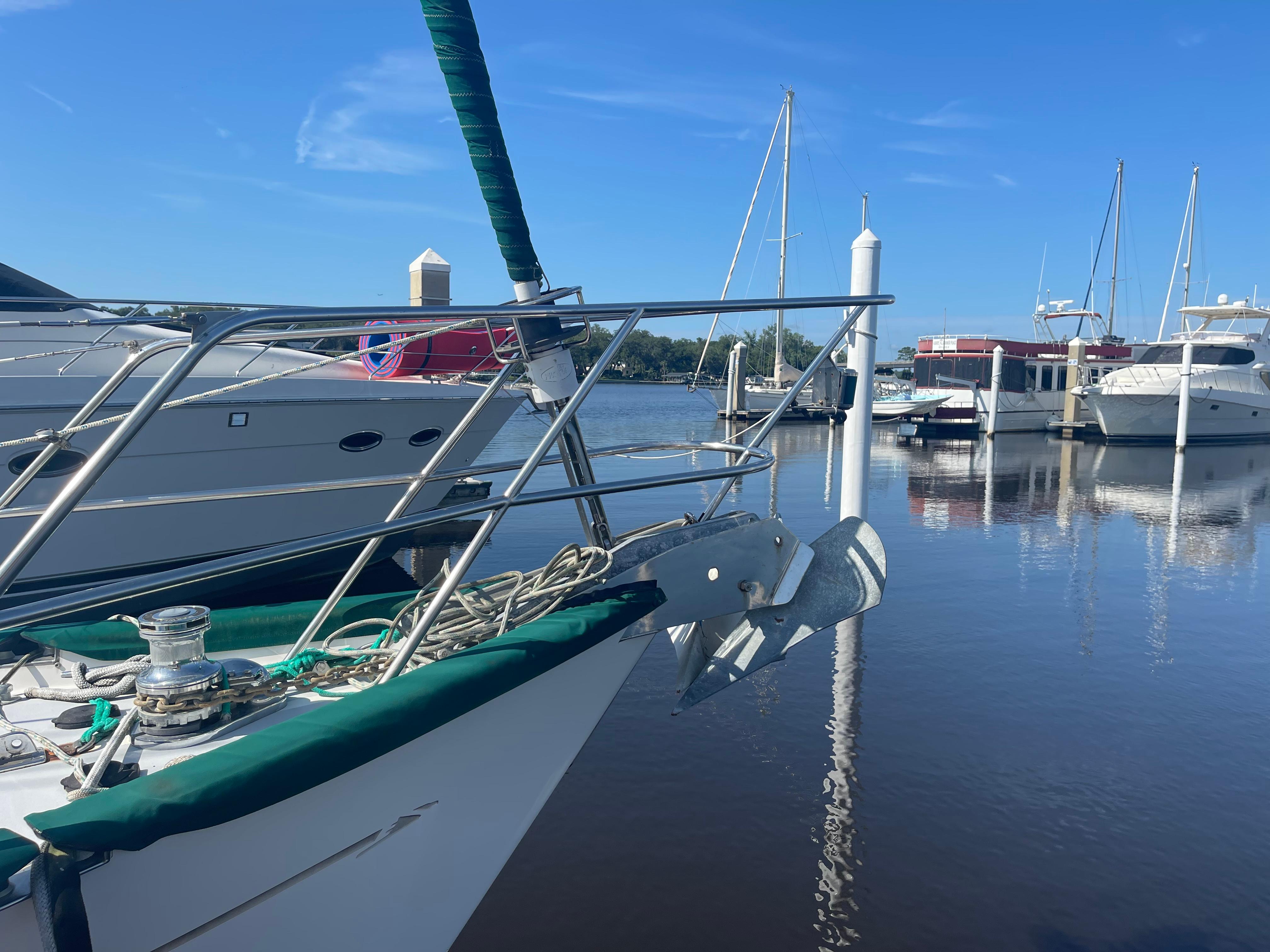 Sailboat Passport 47 AC Plan B 1995 docked in a marina with other boats.