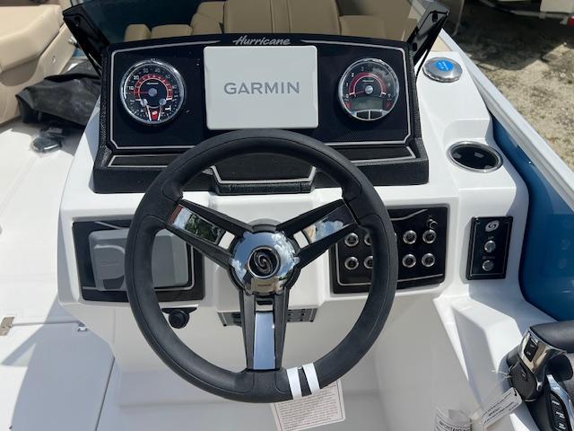 Steering console of 2025 Hurricane FunDeck 2360 SBC OB with Garmin display and controls.