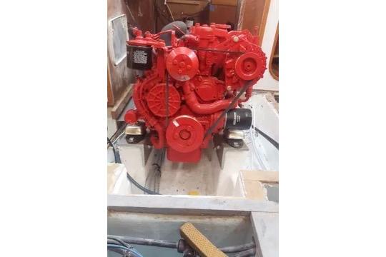 Red engine inside a 1984 Sigma 41 sailboat, showcasing mechanical components.