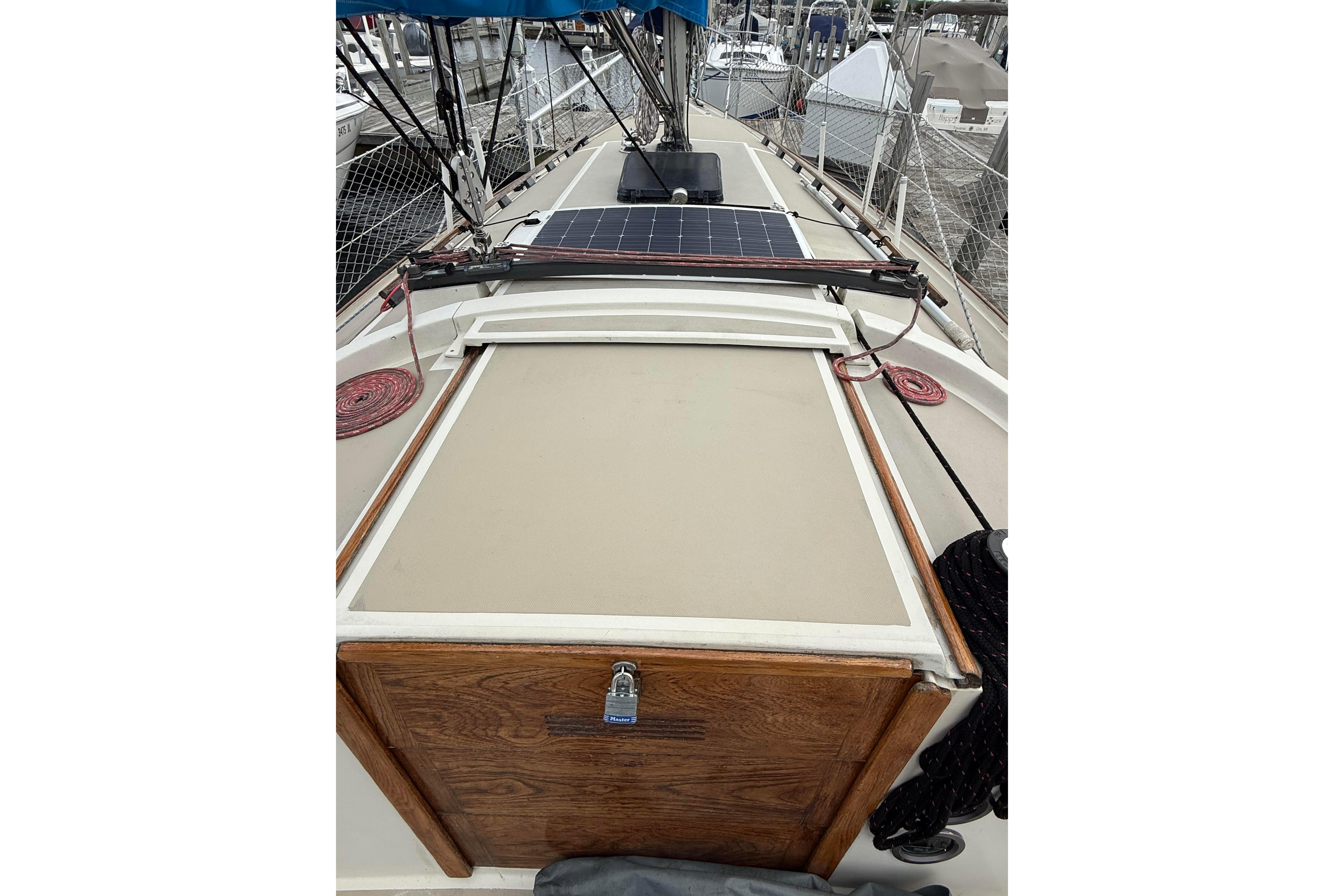 1983 O'Day 34 sailboat deck with solar panel and wooden hatch.